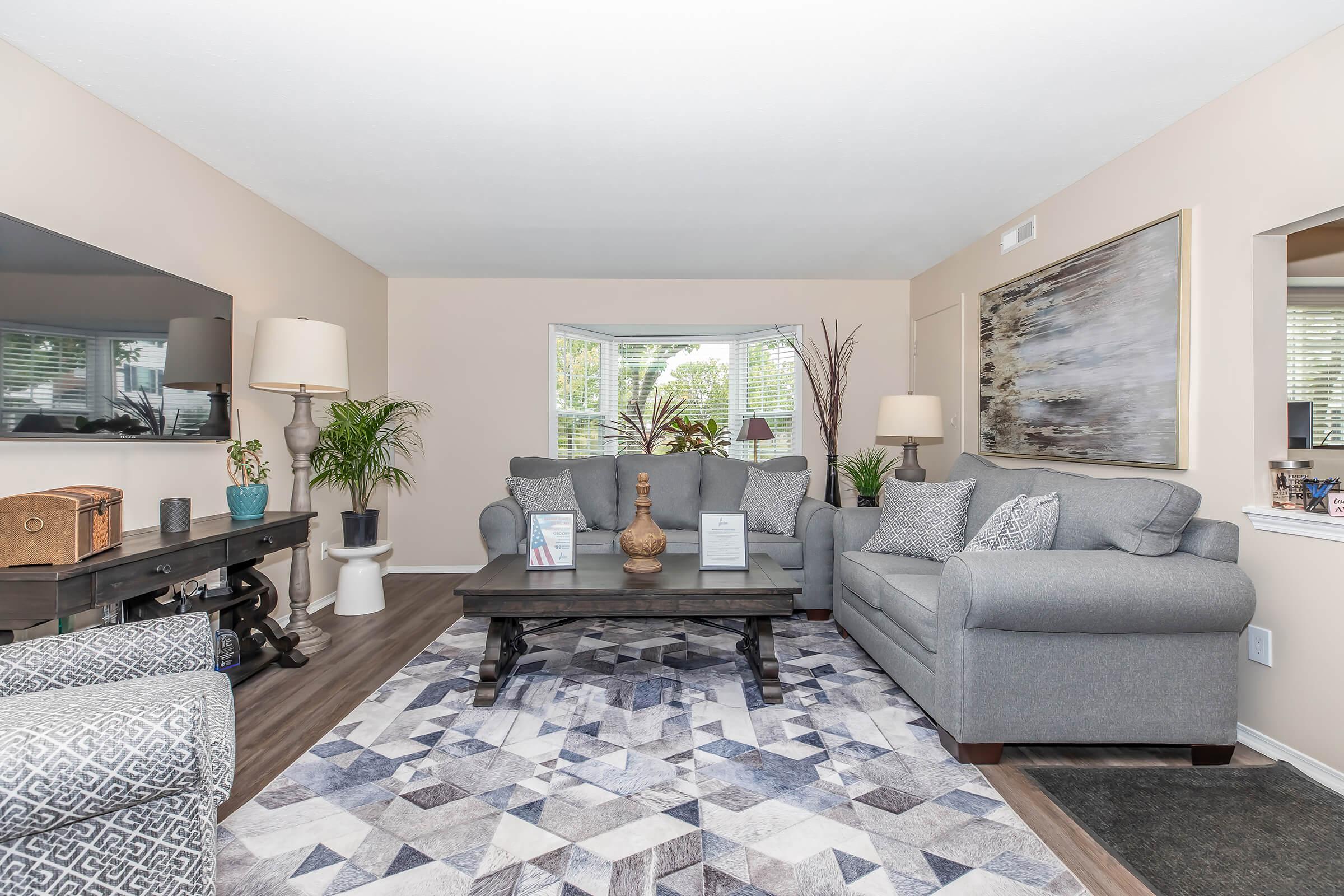 a living room filled with furniture and a large window