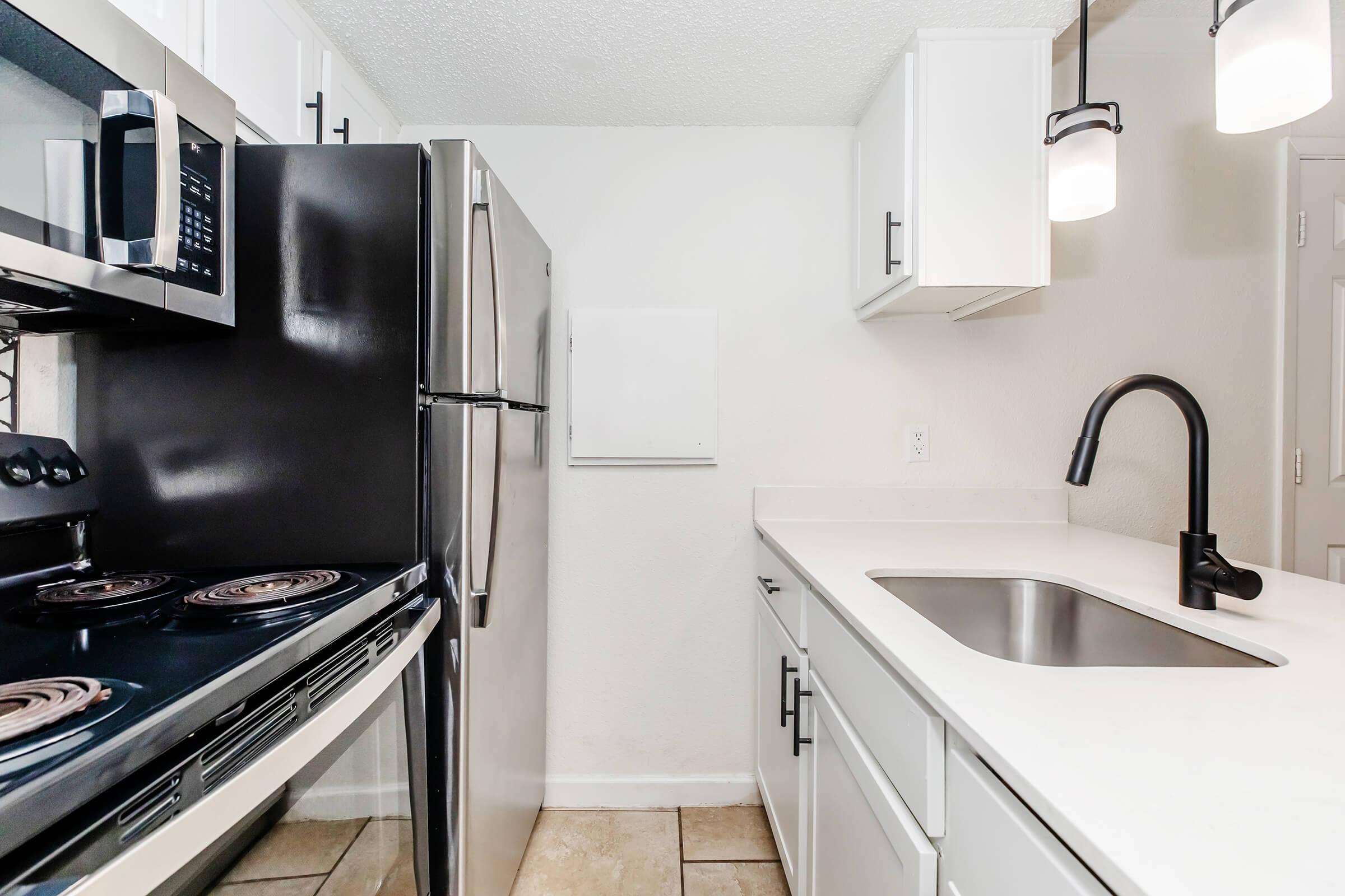 a kitchen with a stove sink and refrigerator