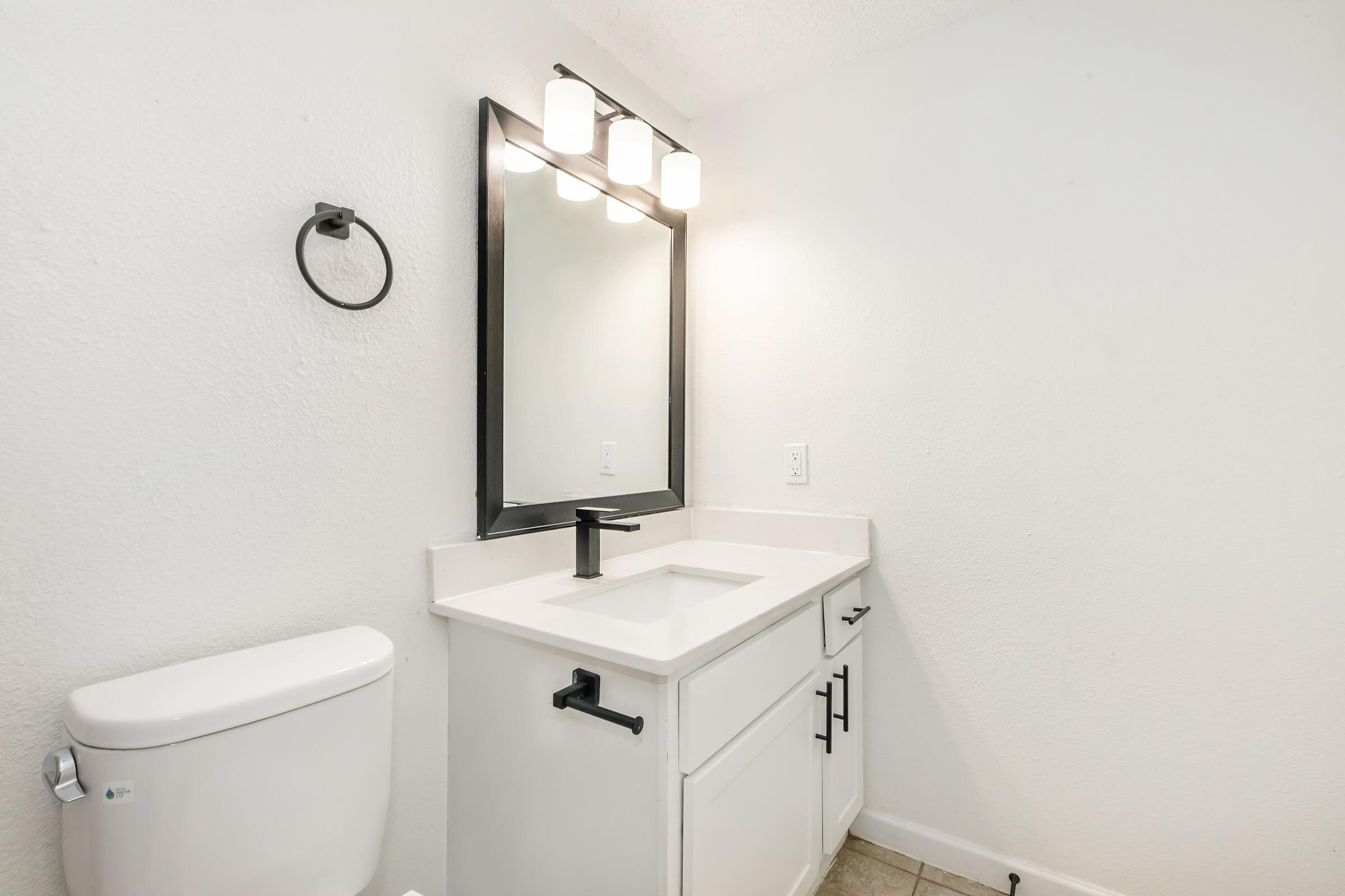 a sink sitting under a mirror