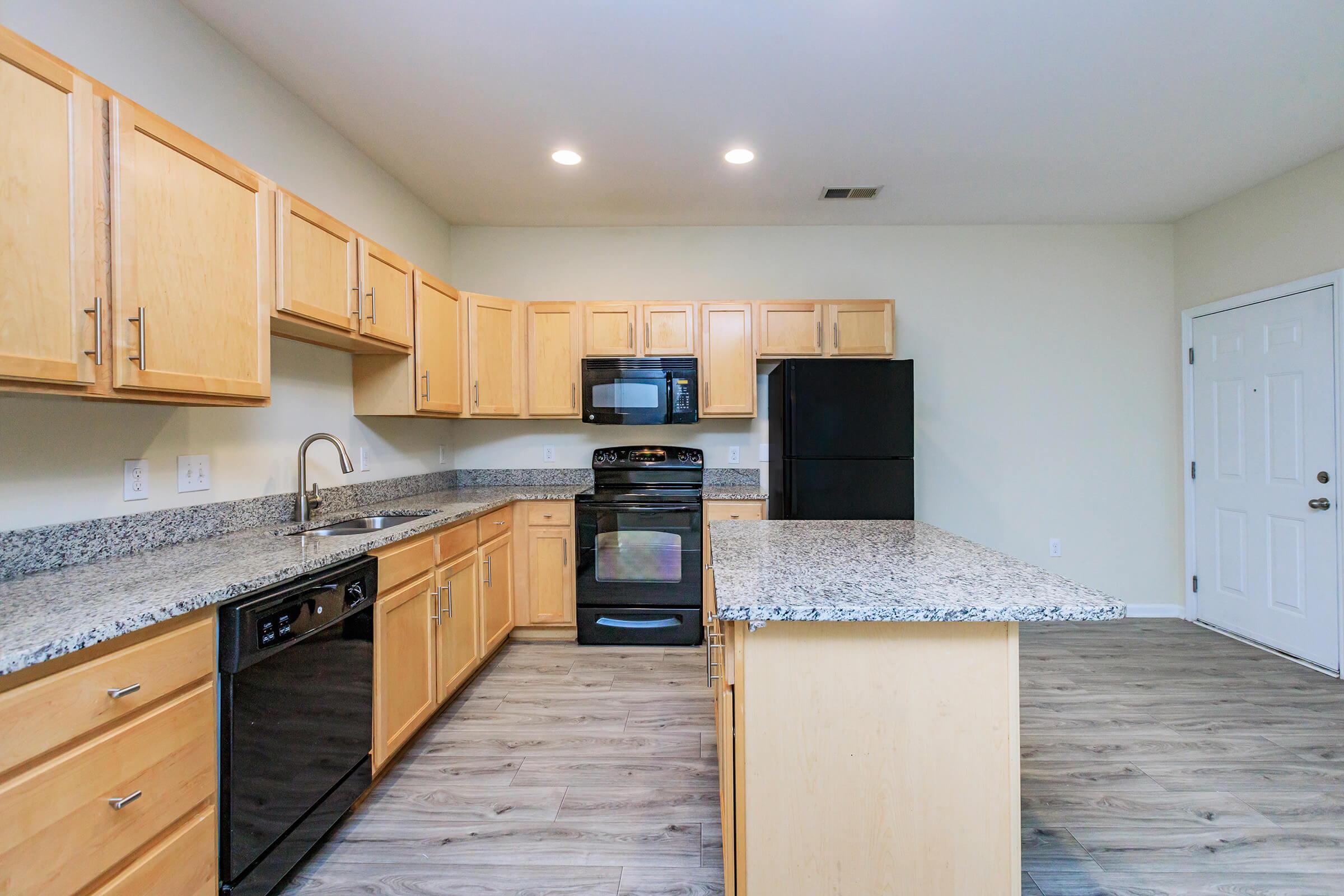 a large kitchen with stainless steel appliances and wooden cabinets