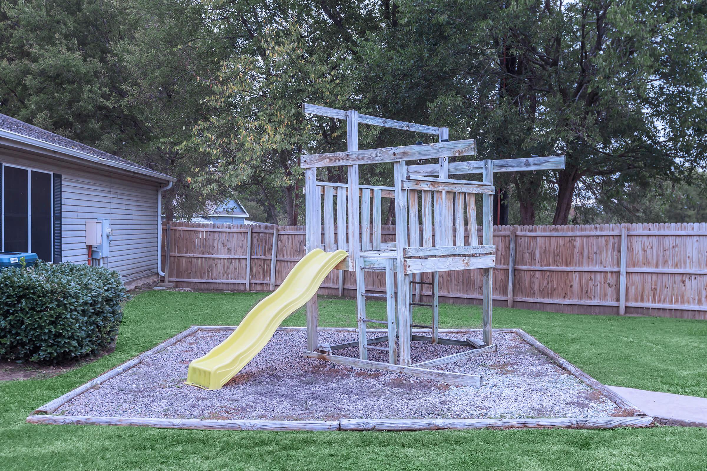a couple of lawn chairs sitting on top of a wooden fence