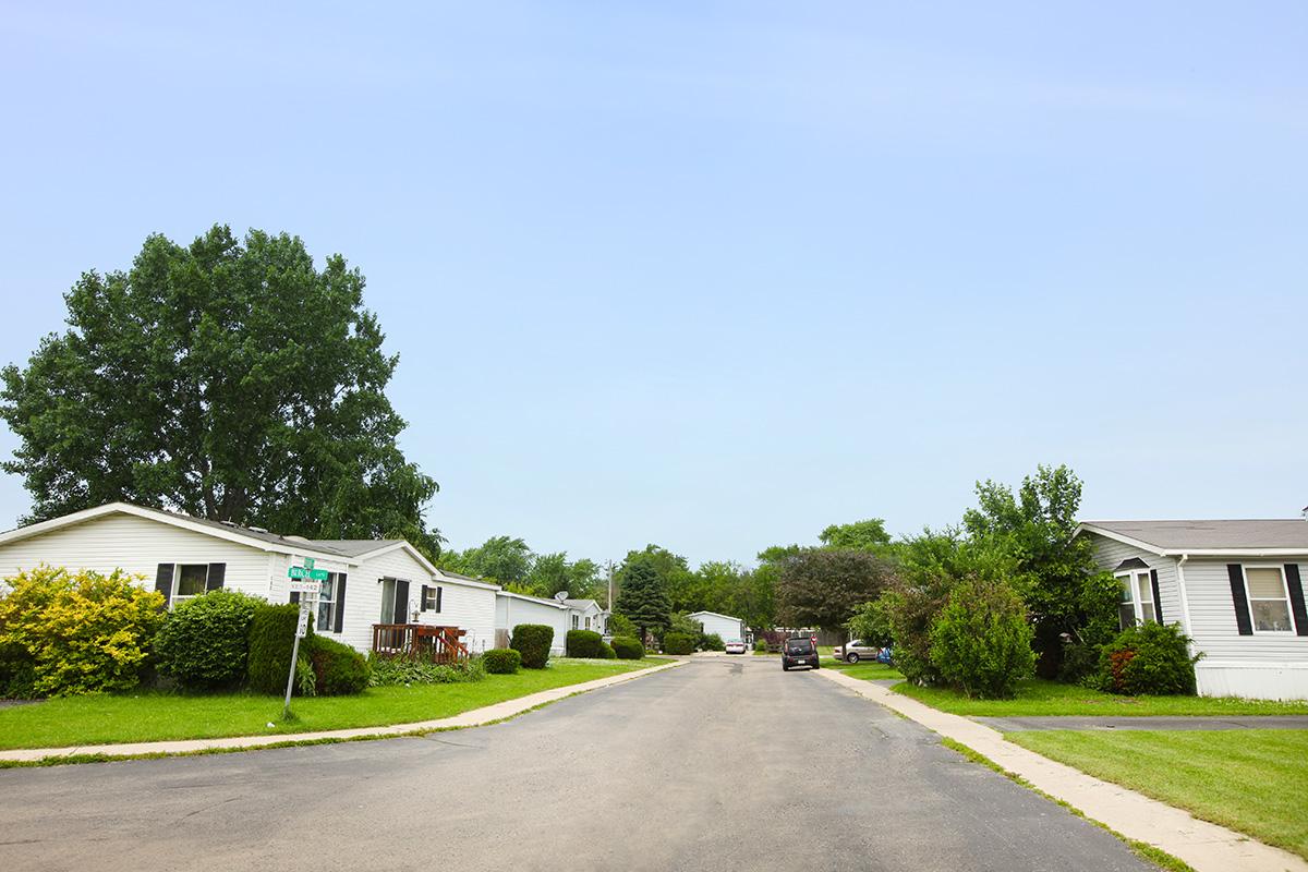 a house that has a sign on the side of a road