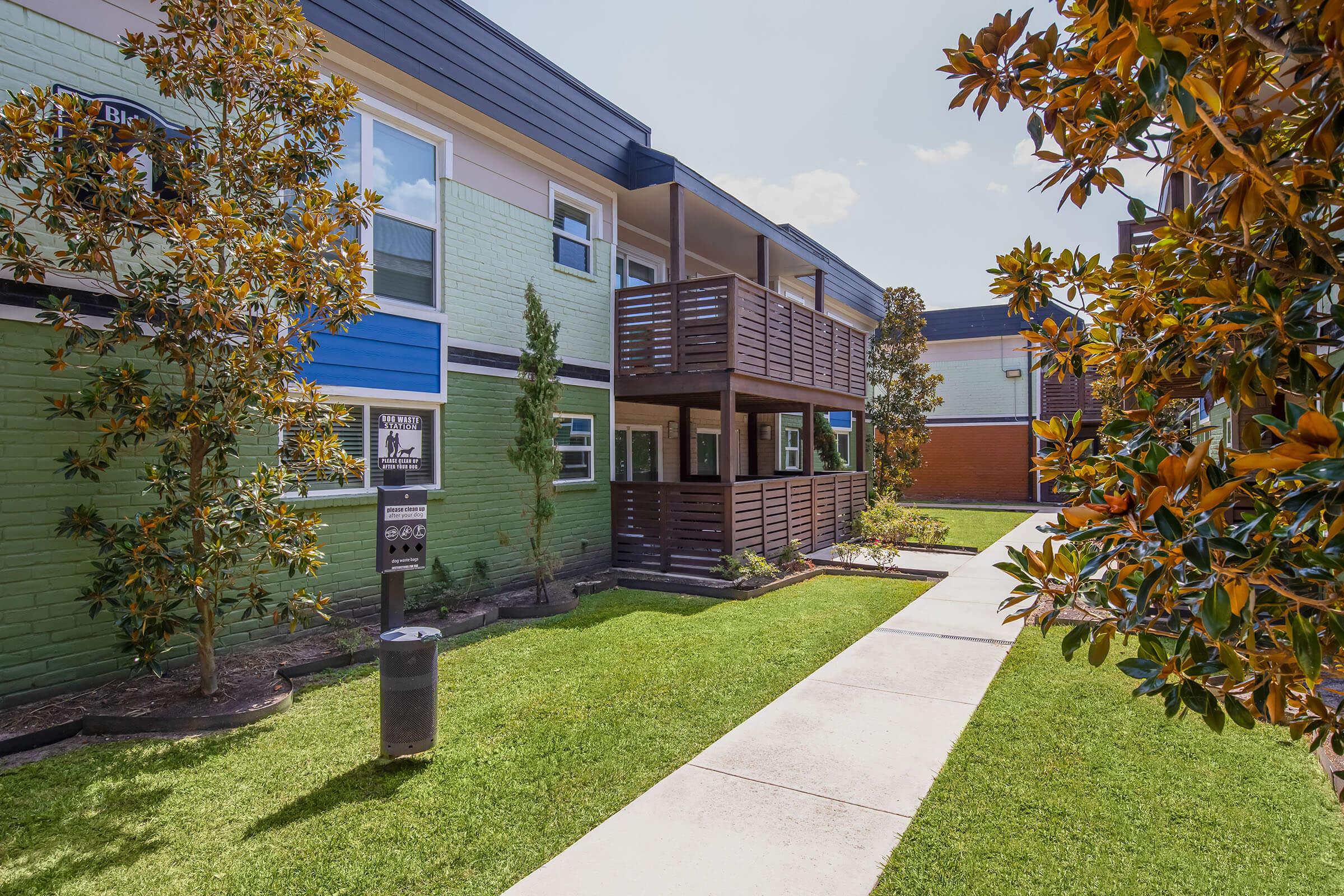 a path with trees on the side of a building