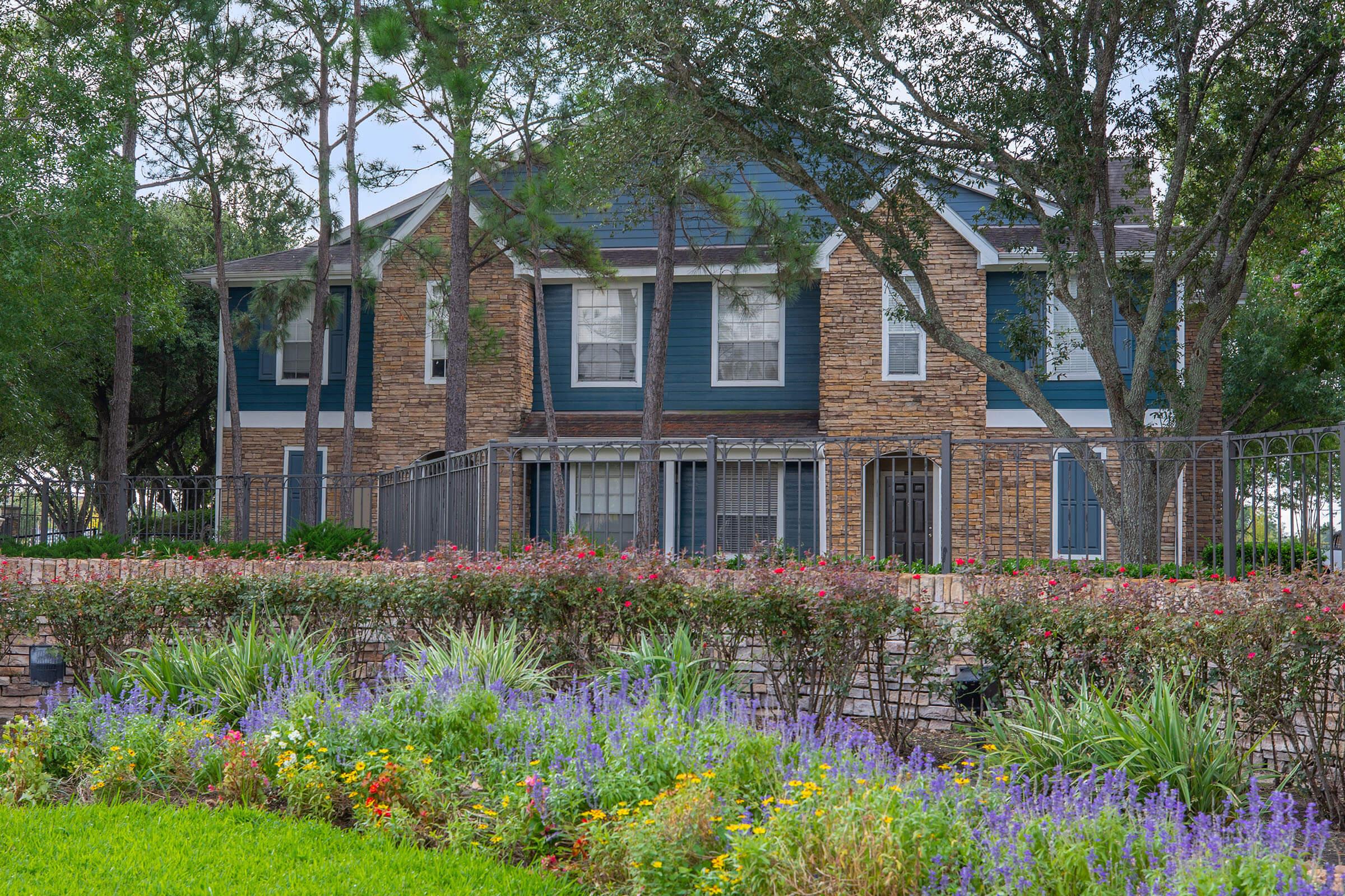 a close up of a flower garden in front of a house