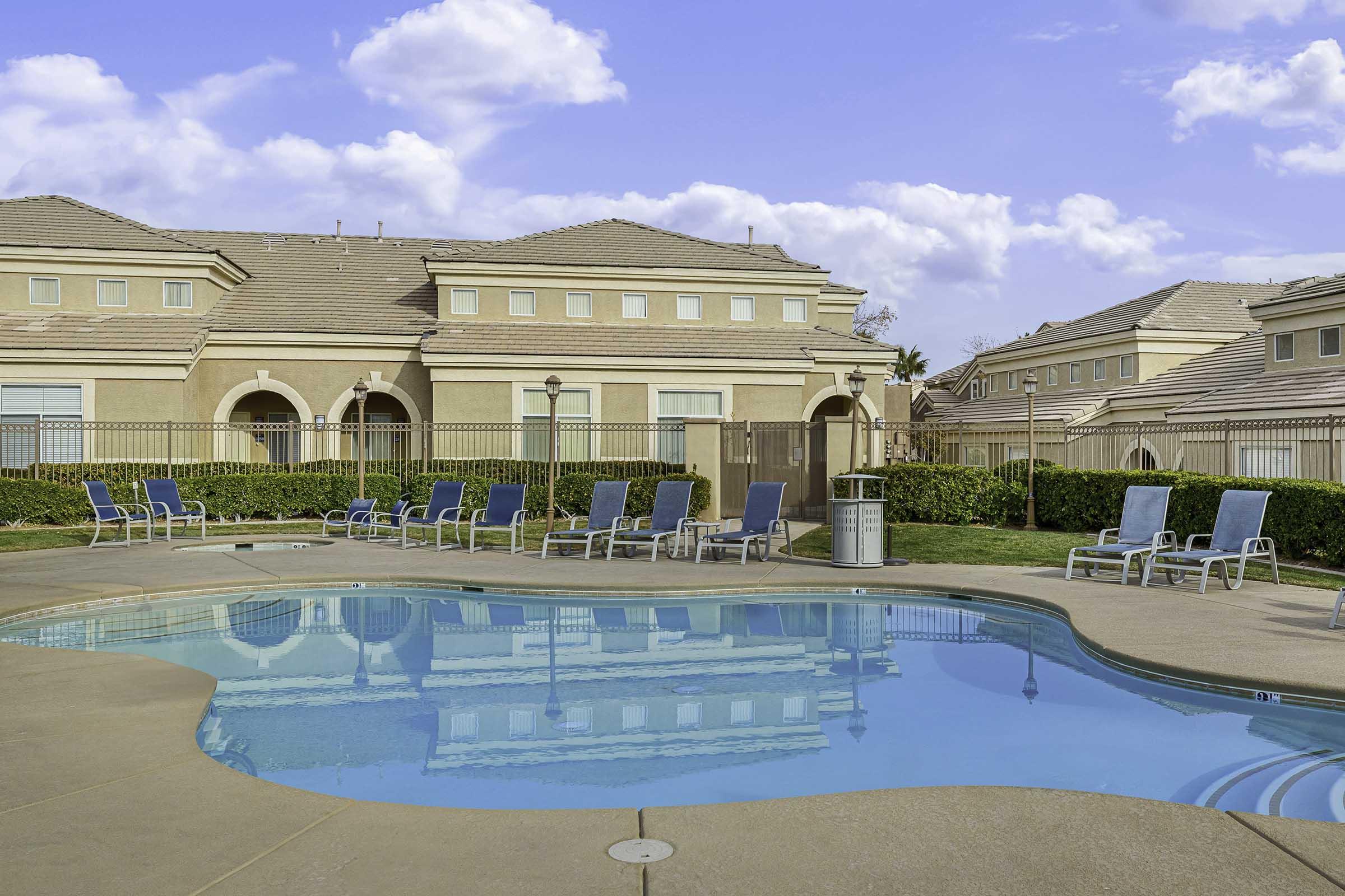 row of lounge chairs next to pool