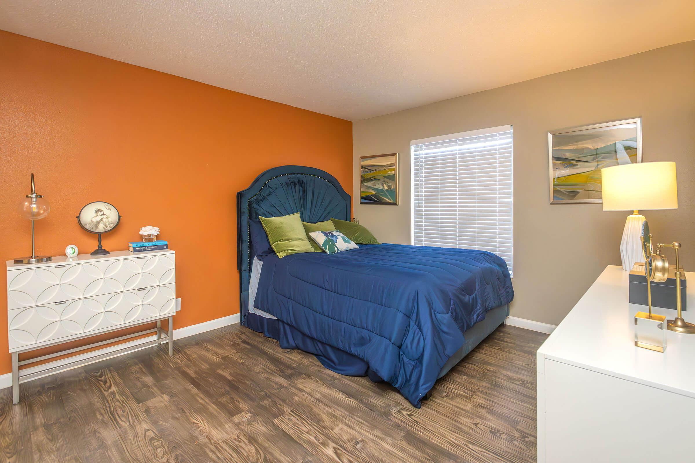 a bedroom with a bed and desk in a room