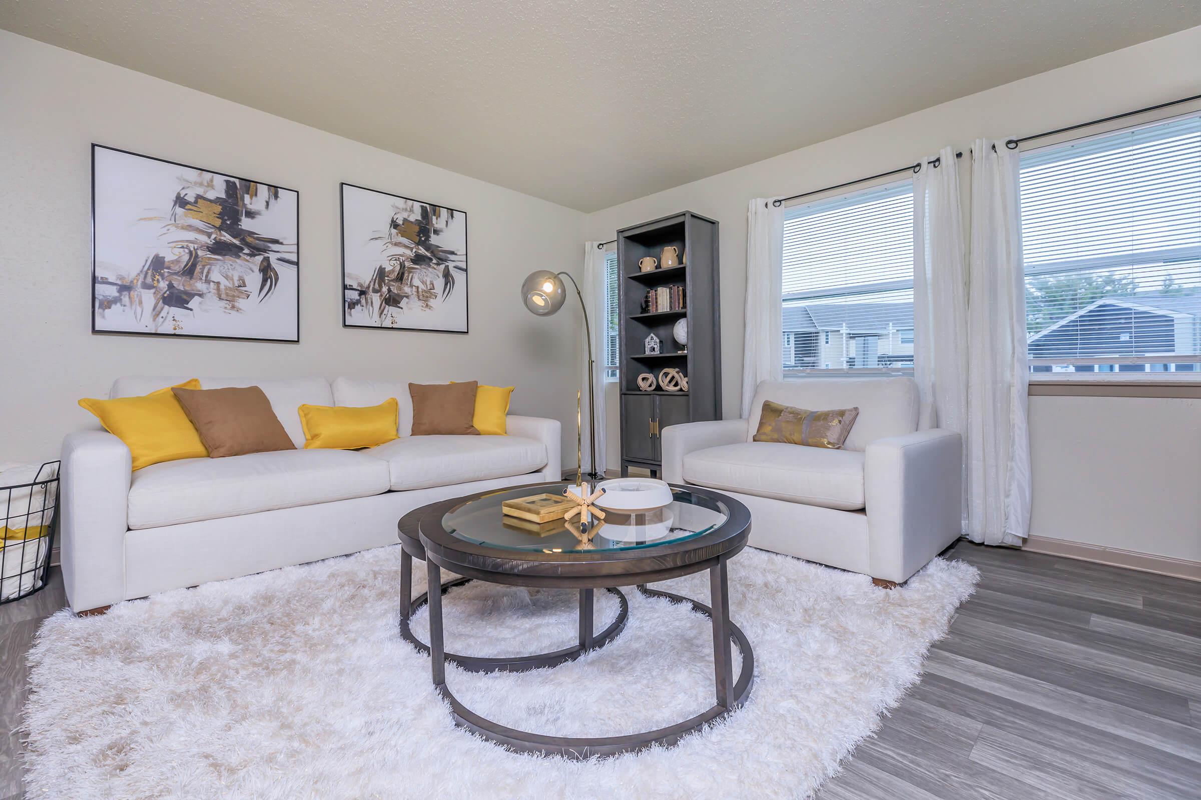 a living room filled with furniture and a large window