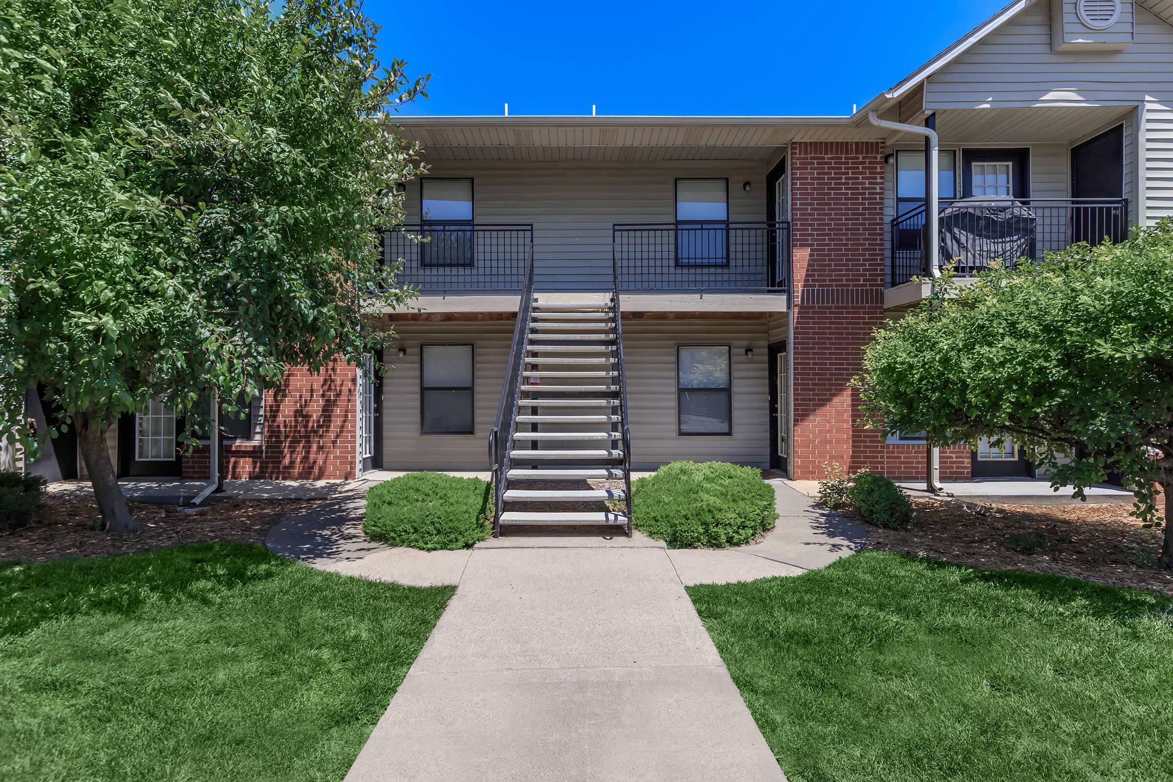 a house with a lawn in front of a brick building