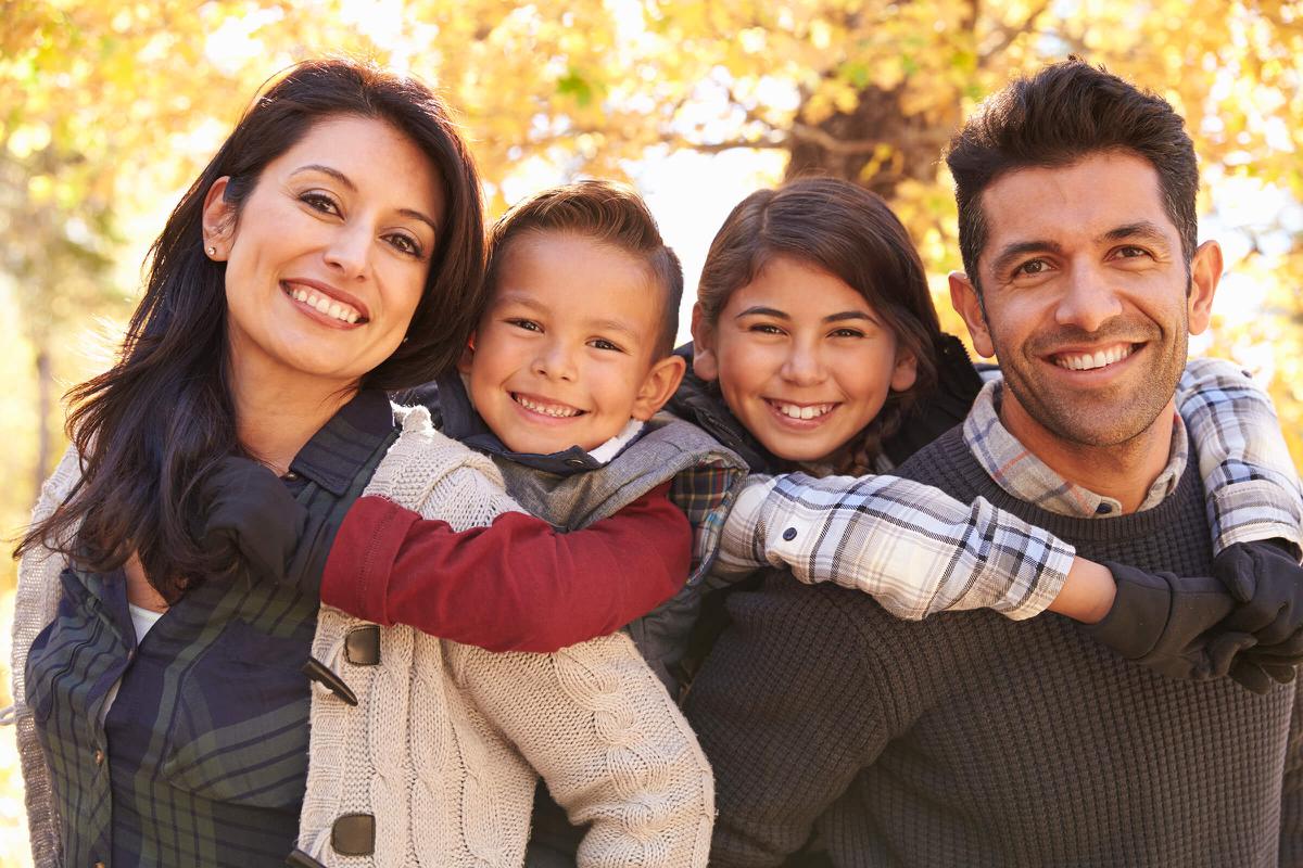 Portrait of happy parents piggybacking kids outdoors iStock-540095942.jpg
