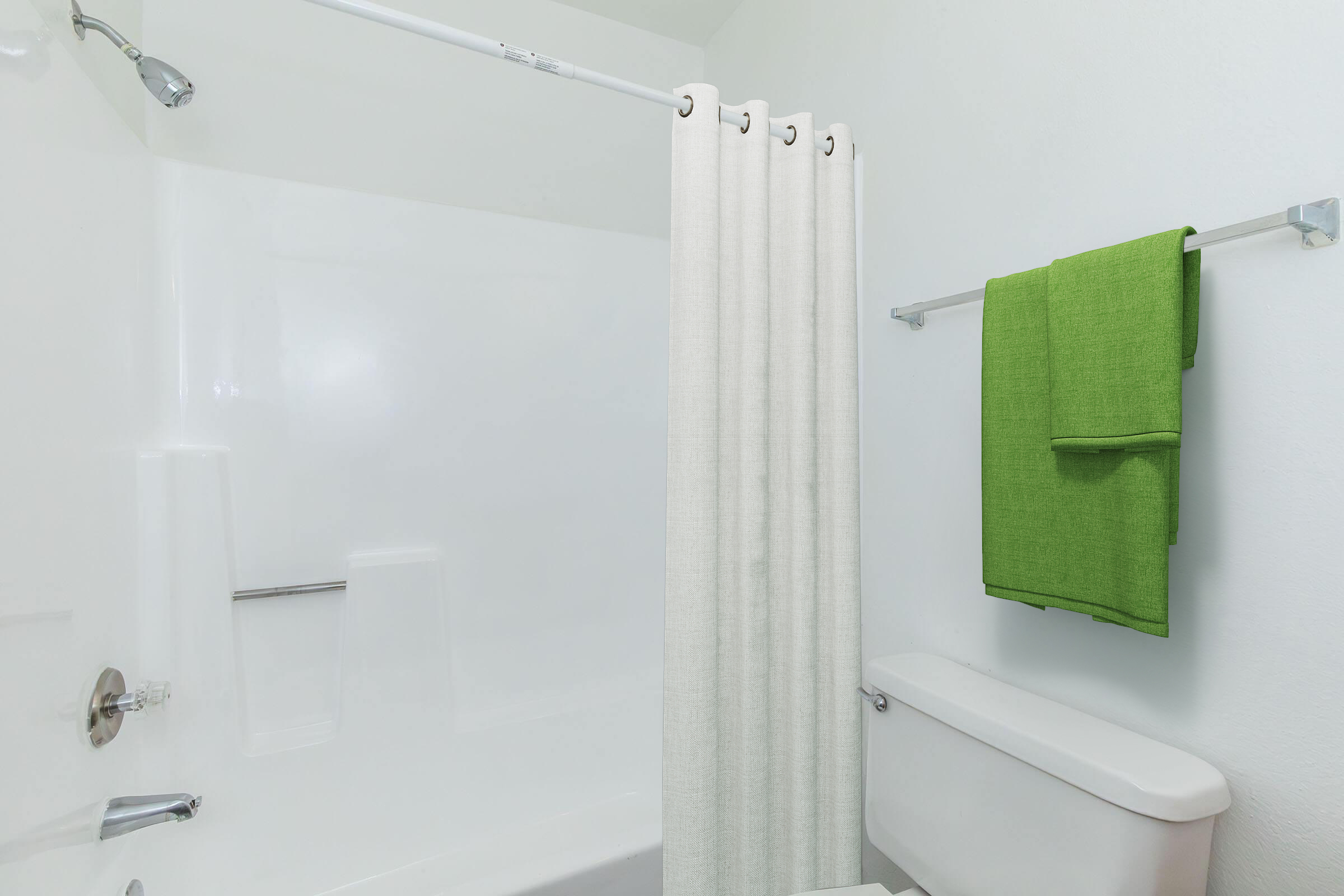 A clean, modern bathroom featuring a white bathtub with a shower curtain in a light color, a green towel hanging on a towel rack, and simple wall design. The overall aesthetic is bright and minimalist.