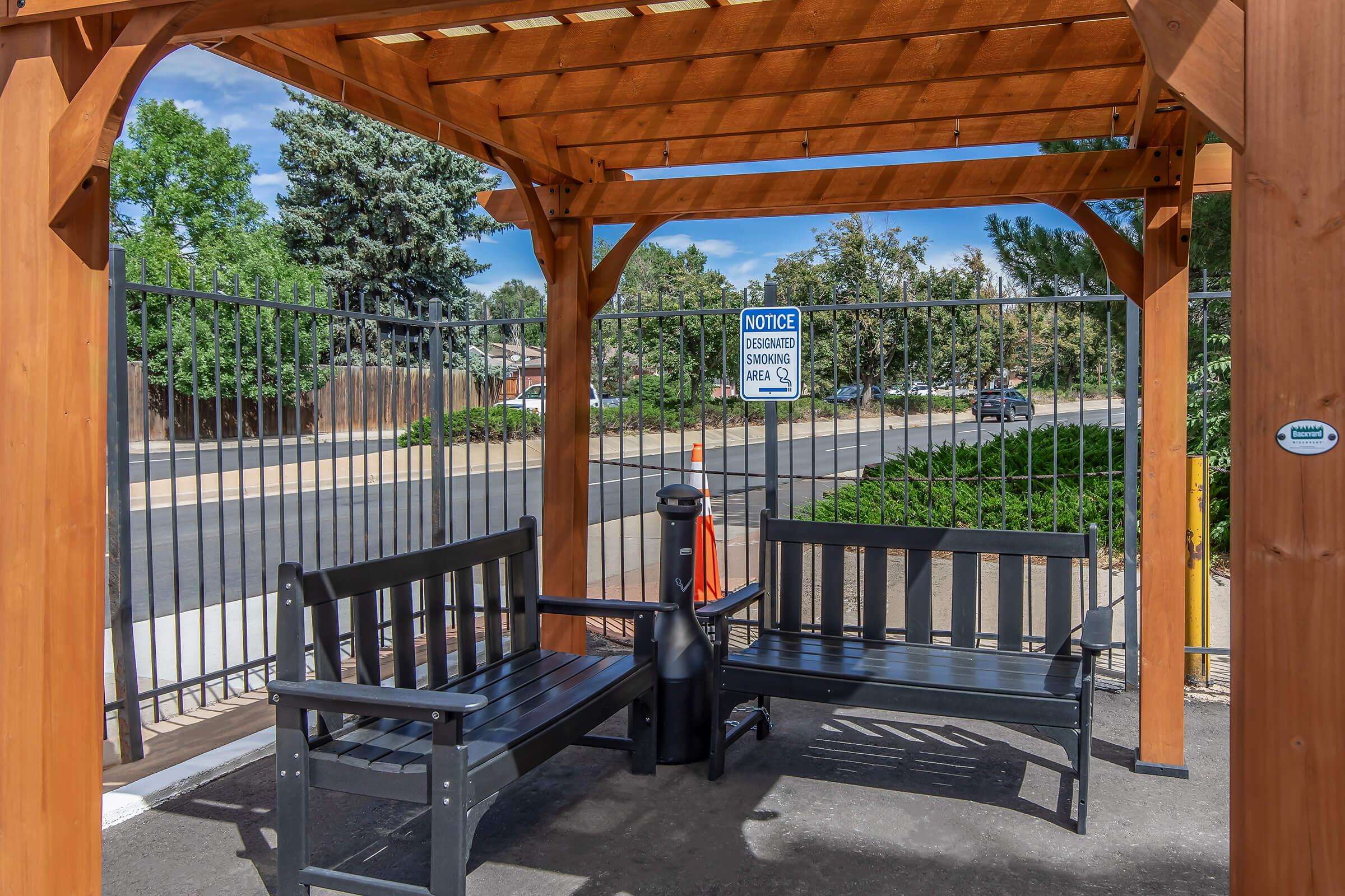 a wooden bench sitting next to a fence