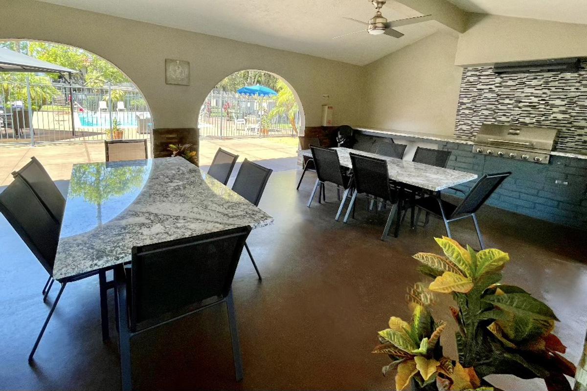 Granite tables and chairs next to the stainless steel barbecue