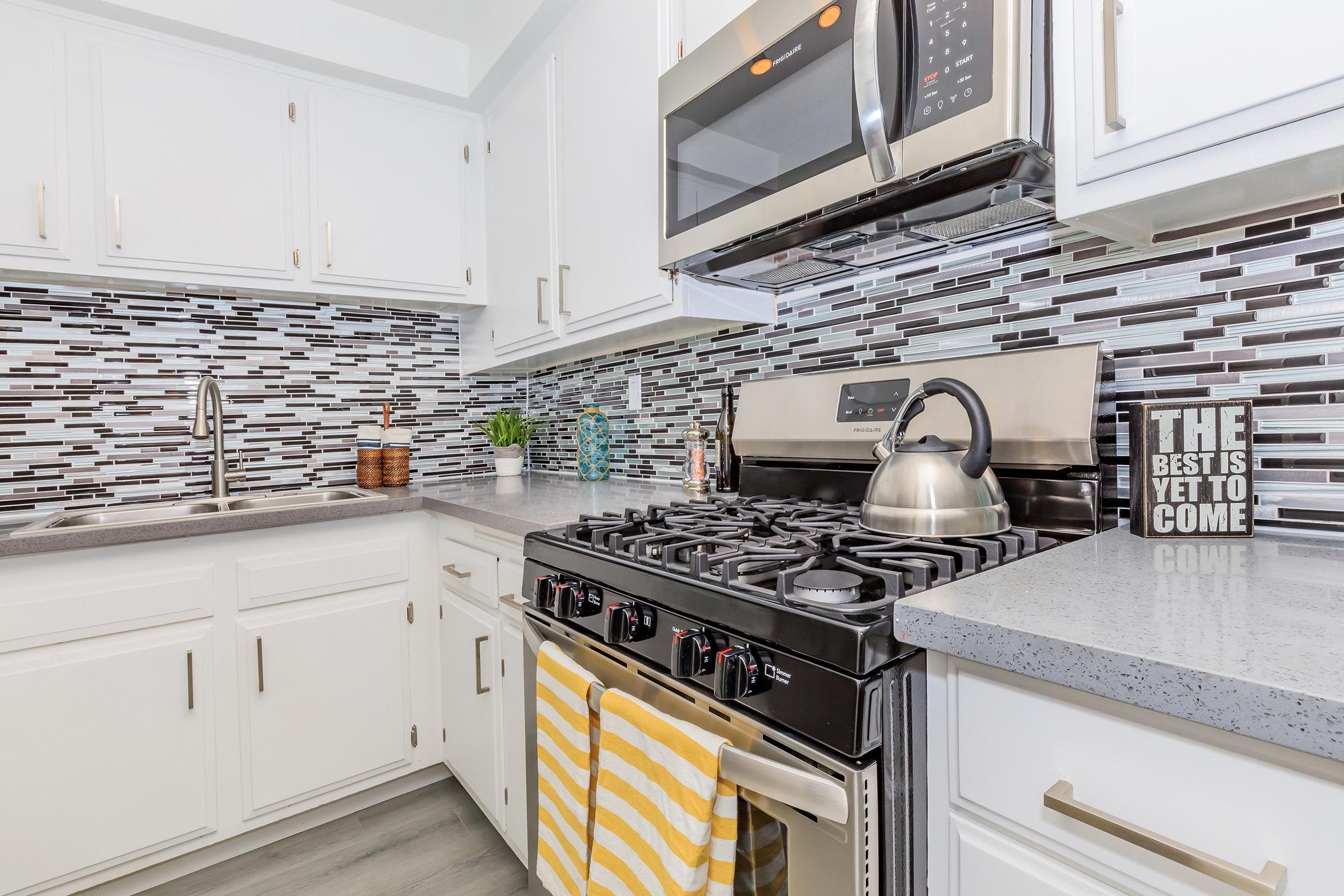 a stove top oven sitting inside of a kitchen