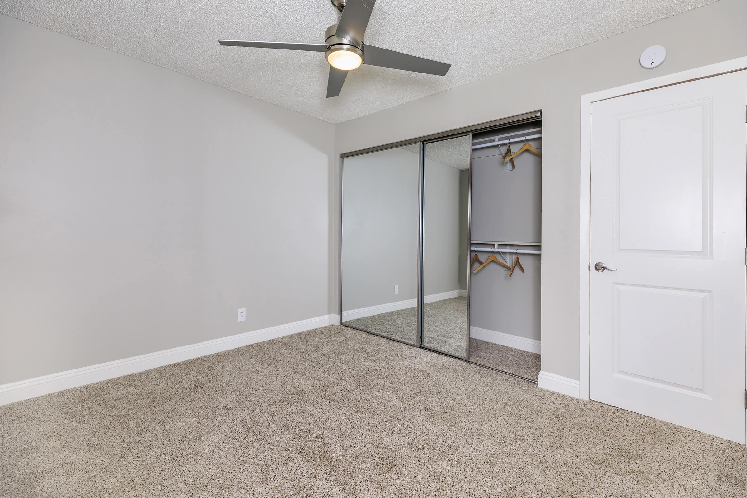 Bedroom with open sliding mirror closet doors