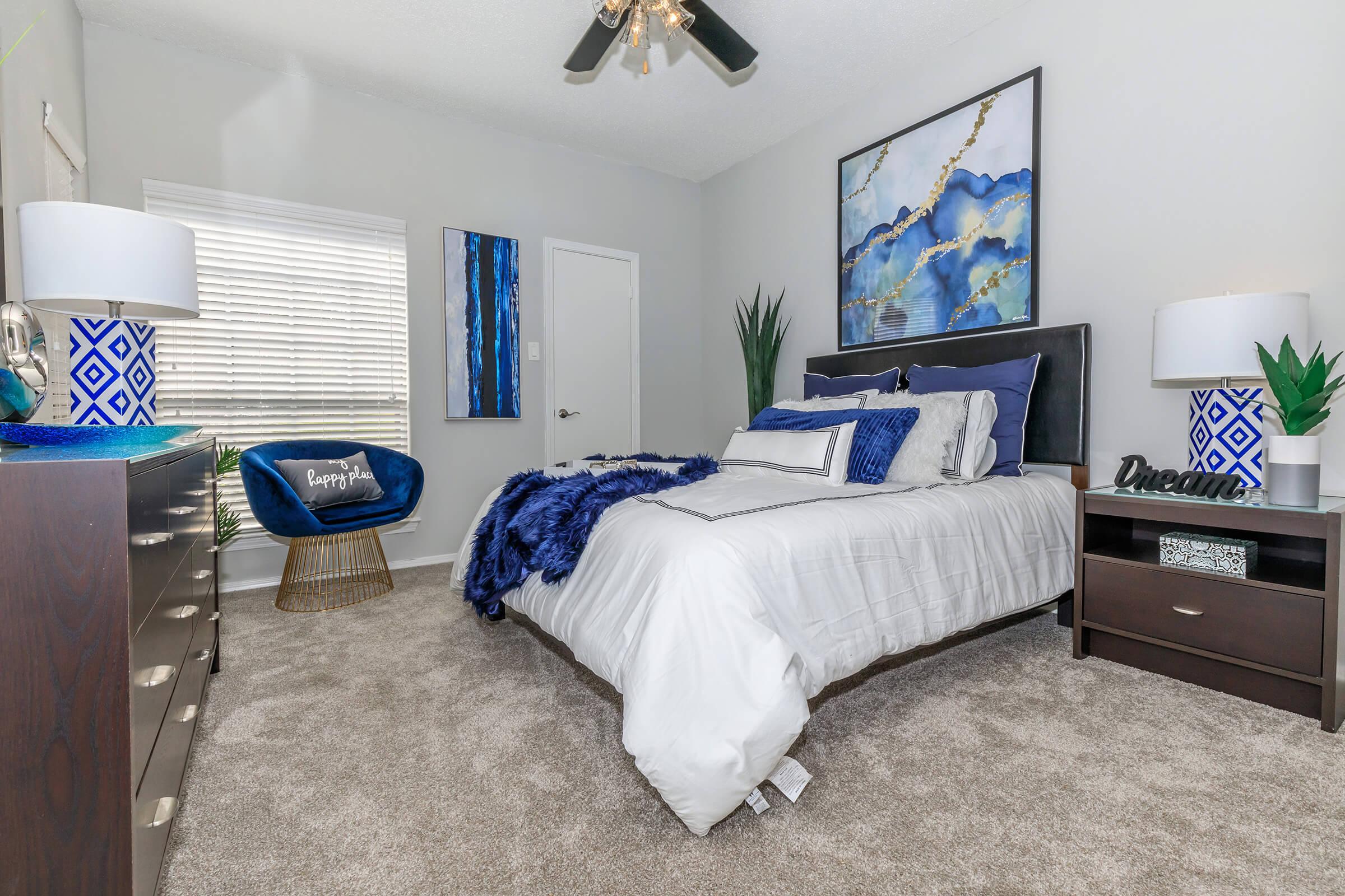 a bedroom with a bed and desk in a room