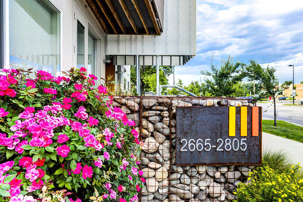 A modern building entrance with a rust-colored sign displaying the numbers 2665-2805.
