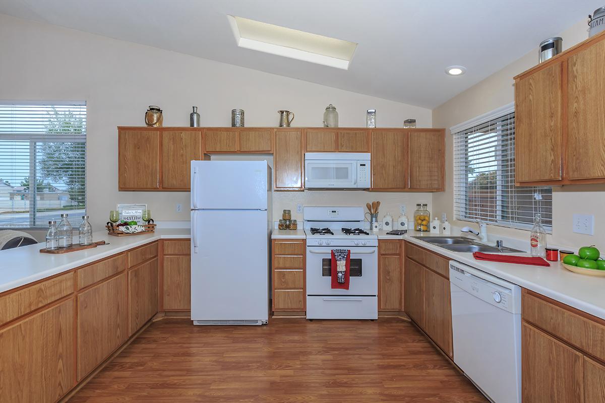 a large kitchen with stainless steel appliances and wooden cabinets