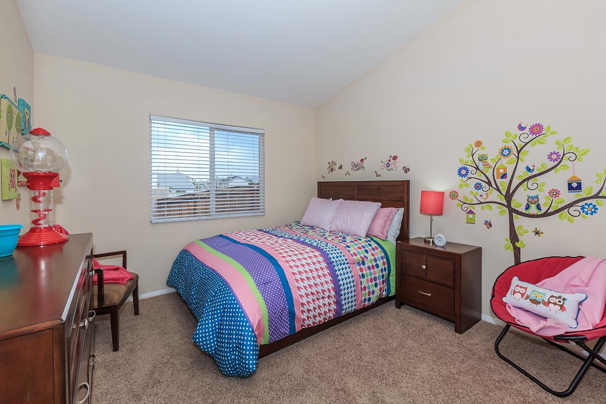 a bedroom with a bed and desk in a room