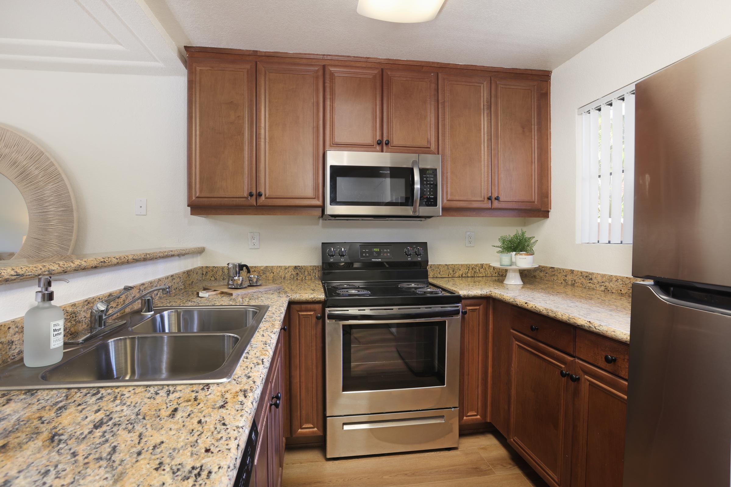 a kitchen with stainless steel appliances and wooden cabinets