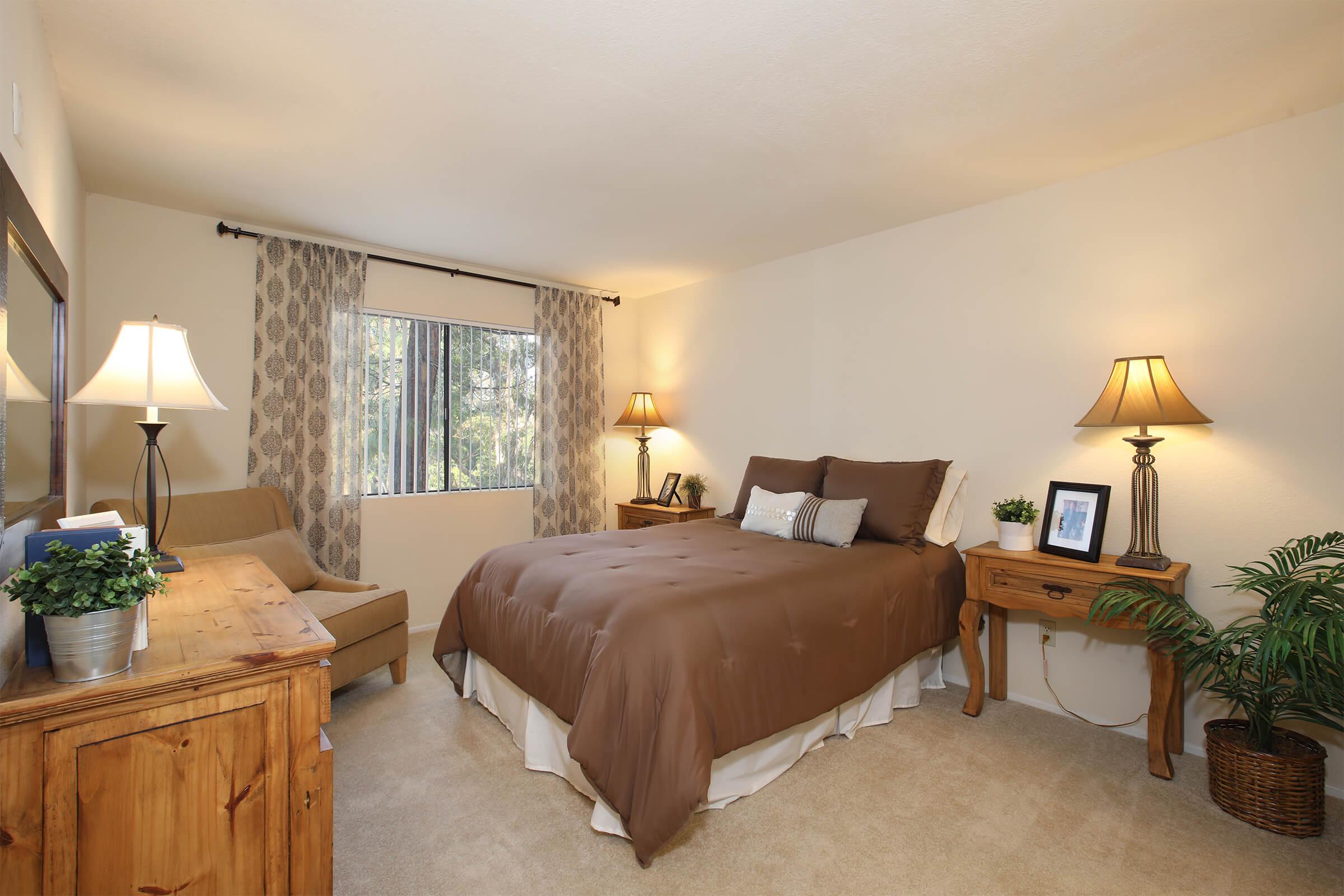 a bedroom with a bed and desk in a hotel room