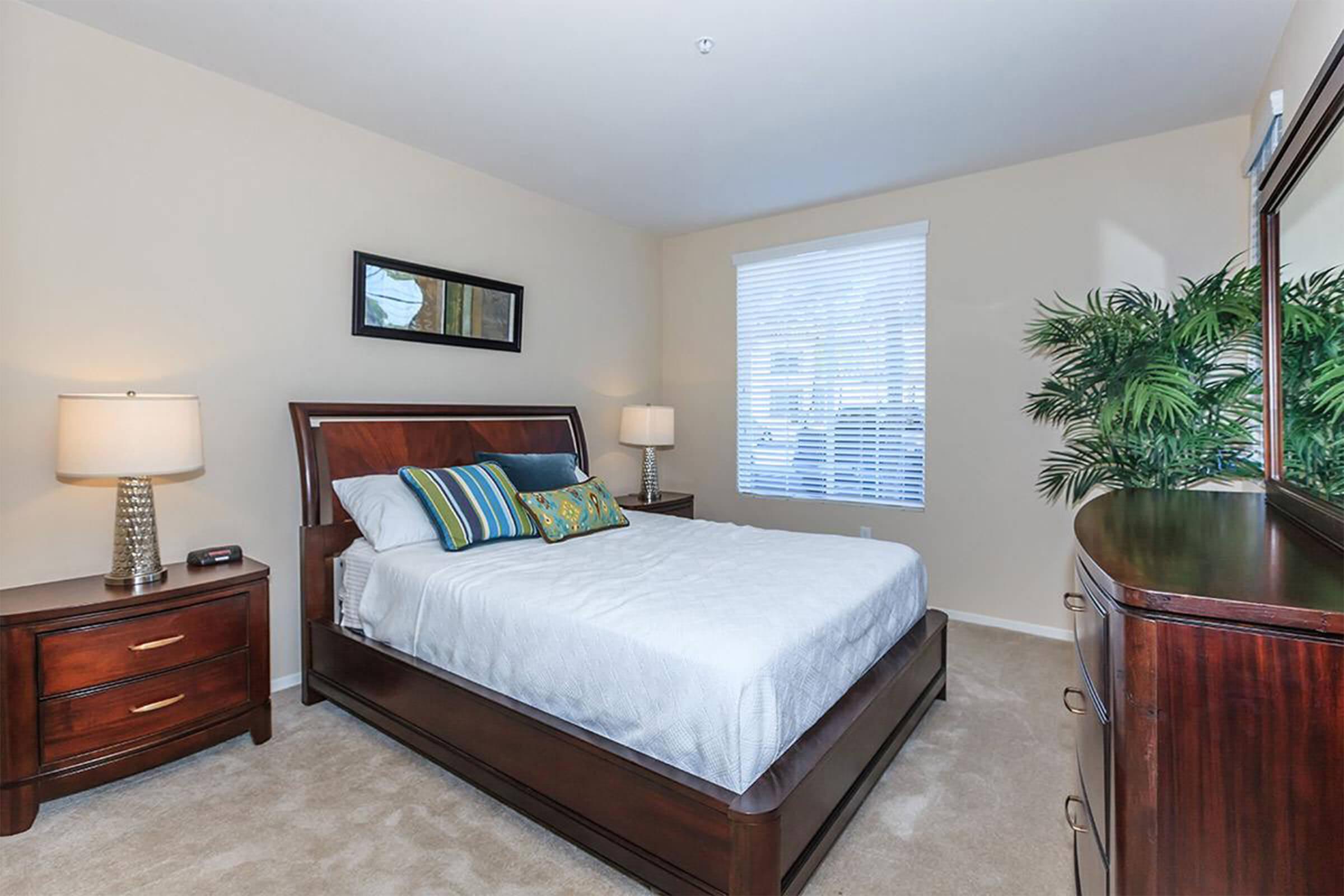 a bedroom with a bed and desk in a room