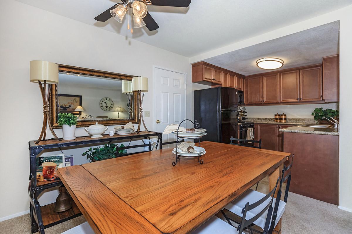 a kitchen with wooden cabinets and a dining room table