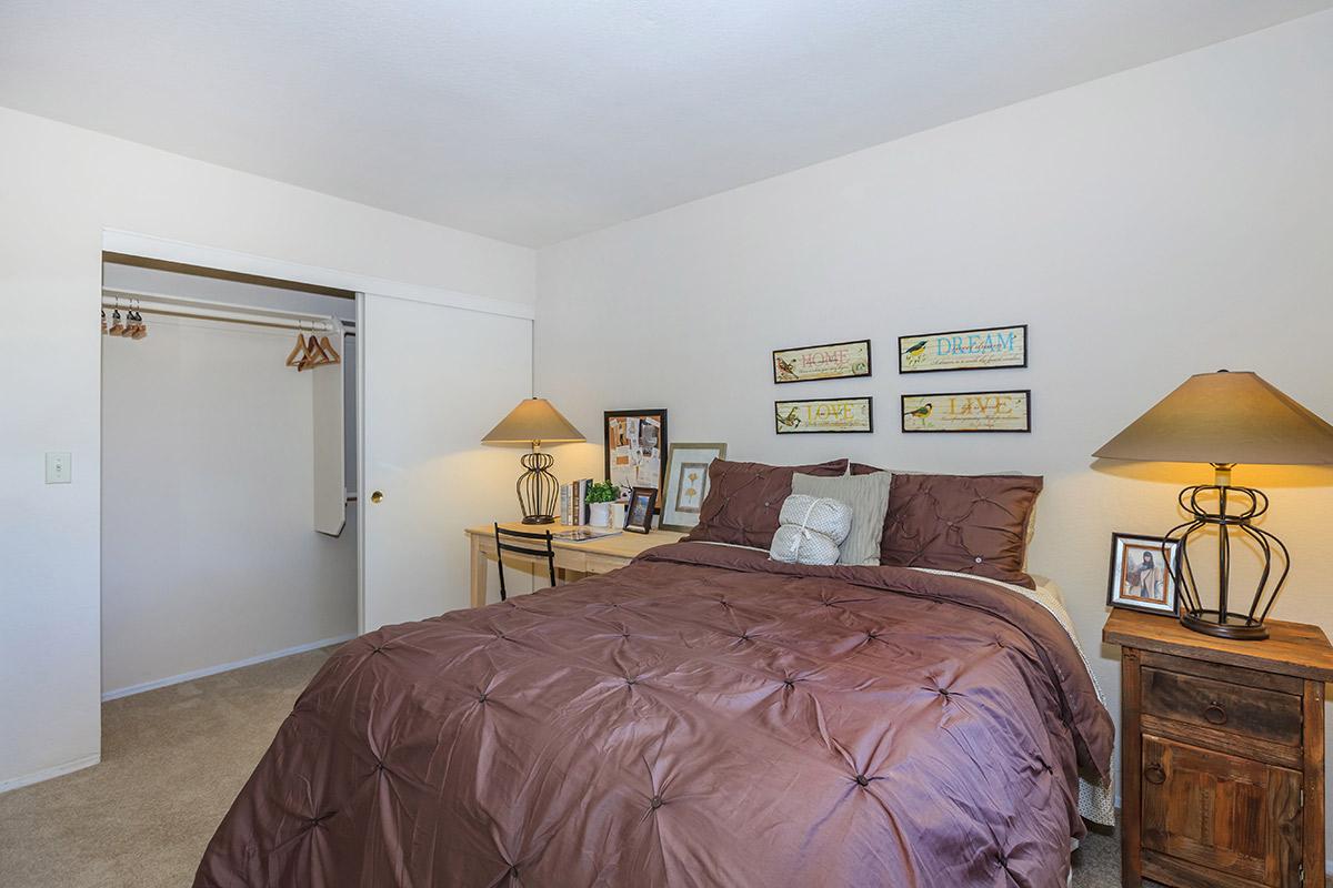 a bedroom with a bed and desk in a room