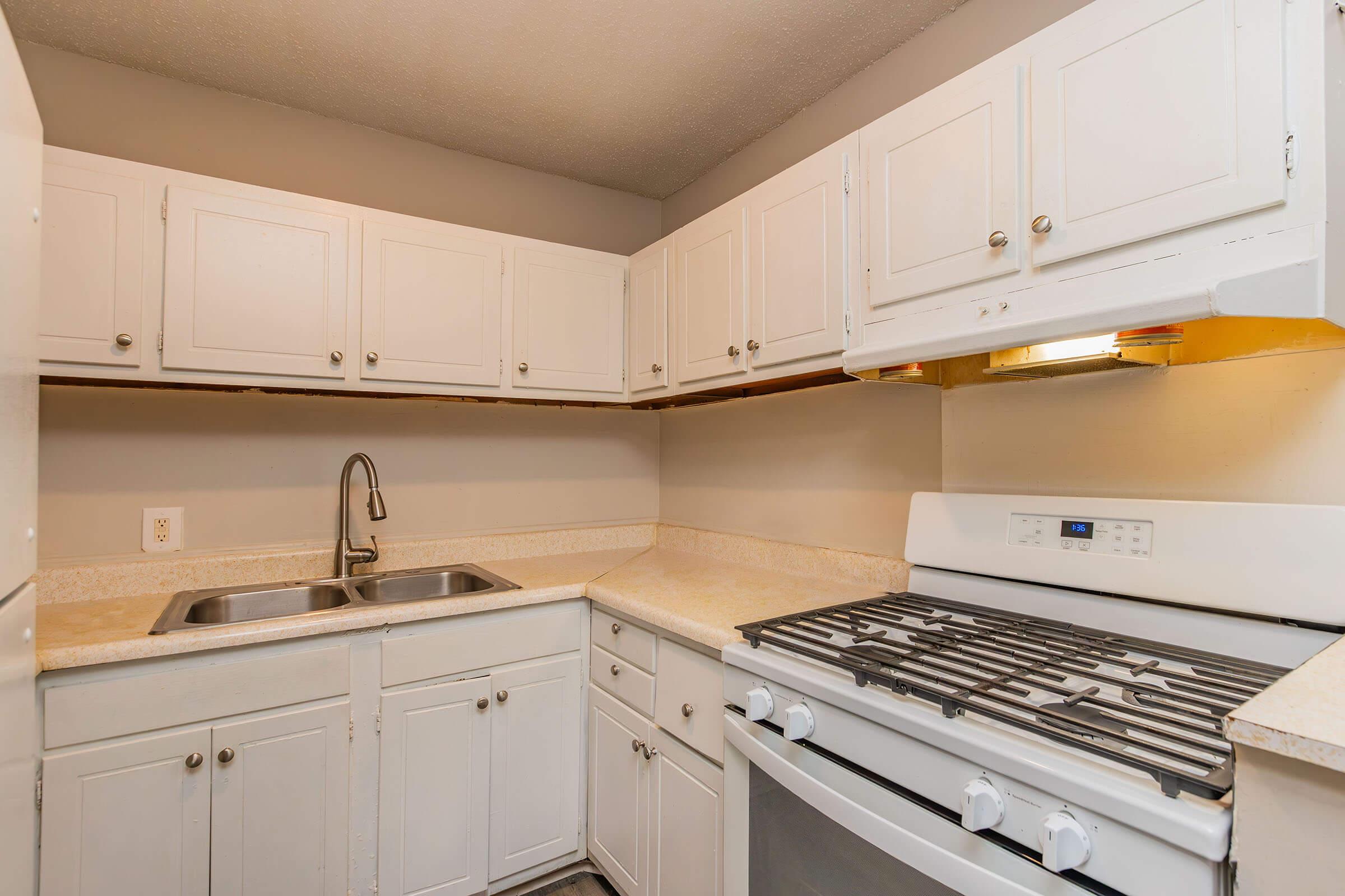 a stove top oven sitting inside of a kitchen