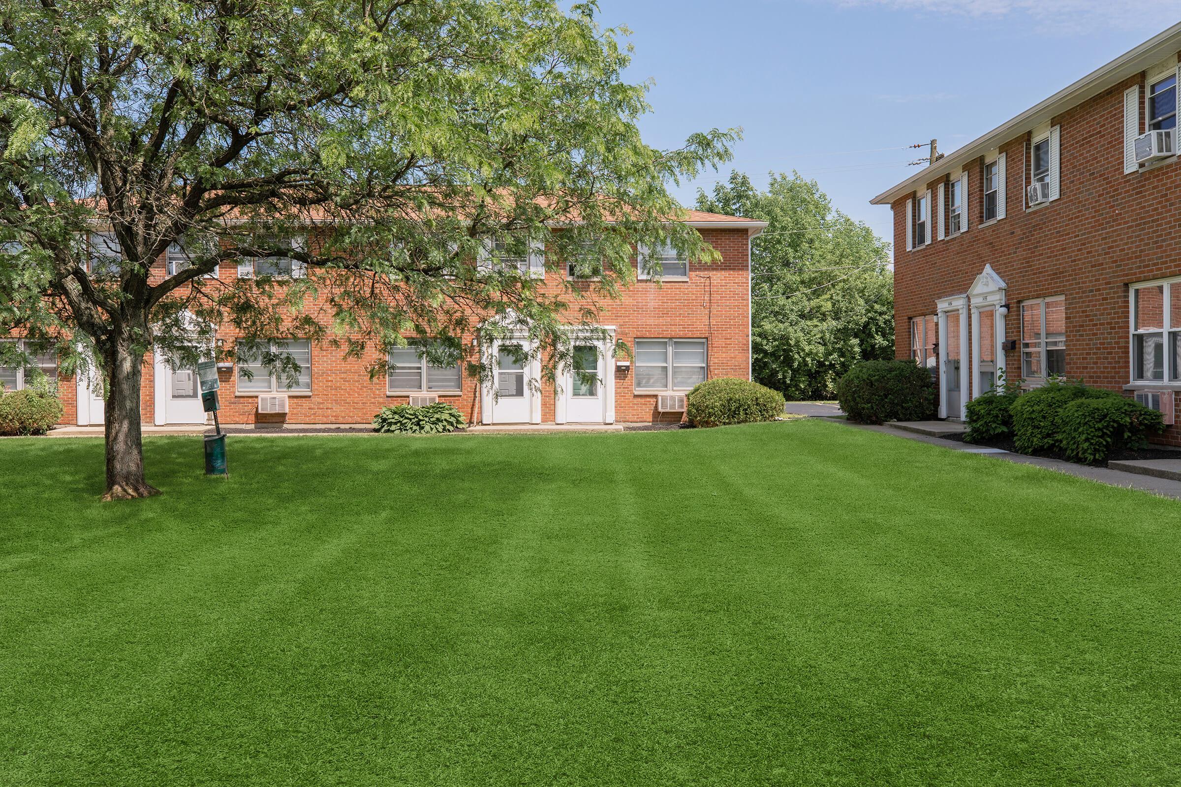 a large lawn in front of a brick building