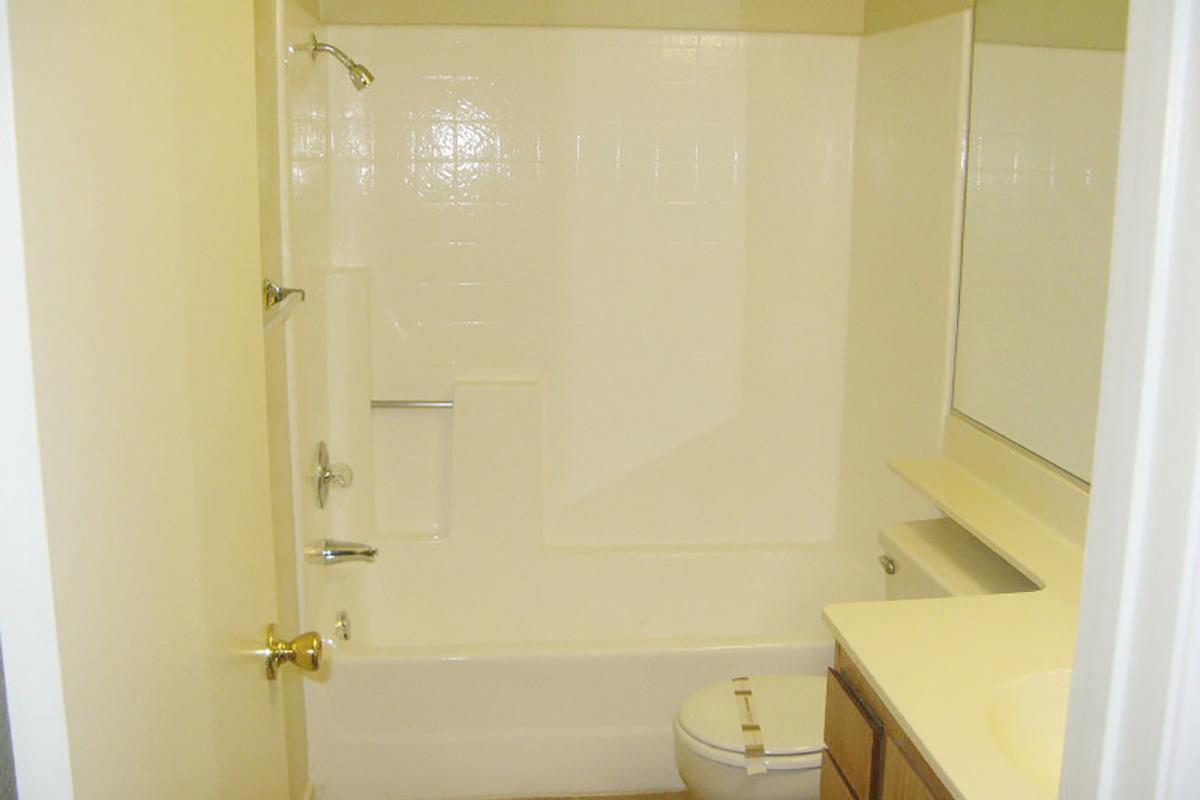 a white tub sitting next to a shower