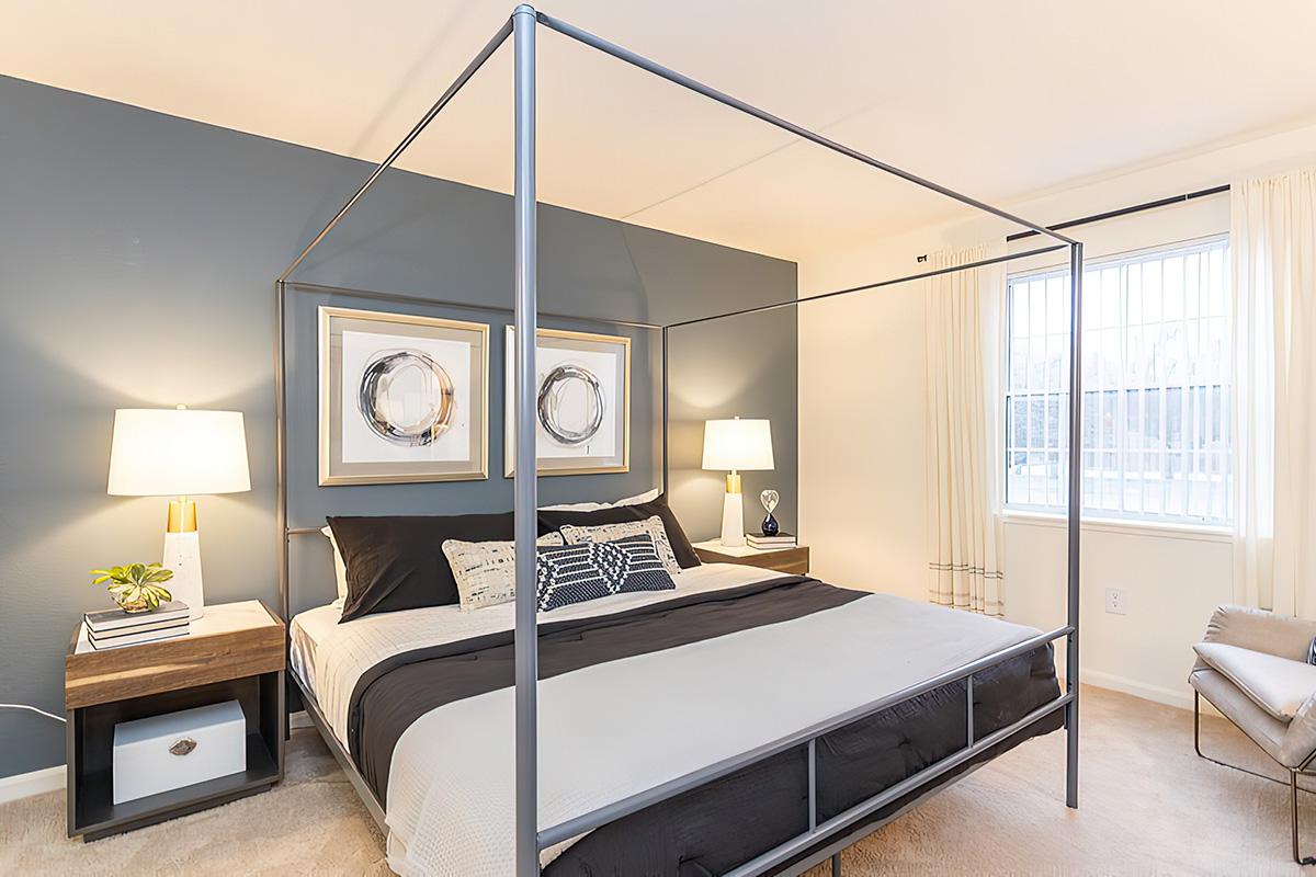 a bedroom with a bed and desk in a room