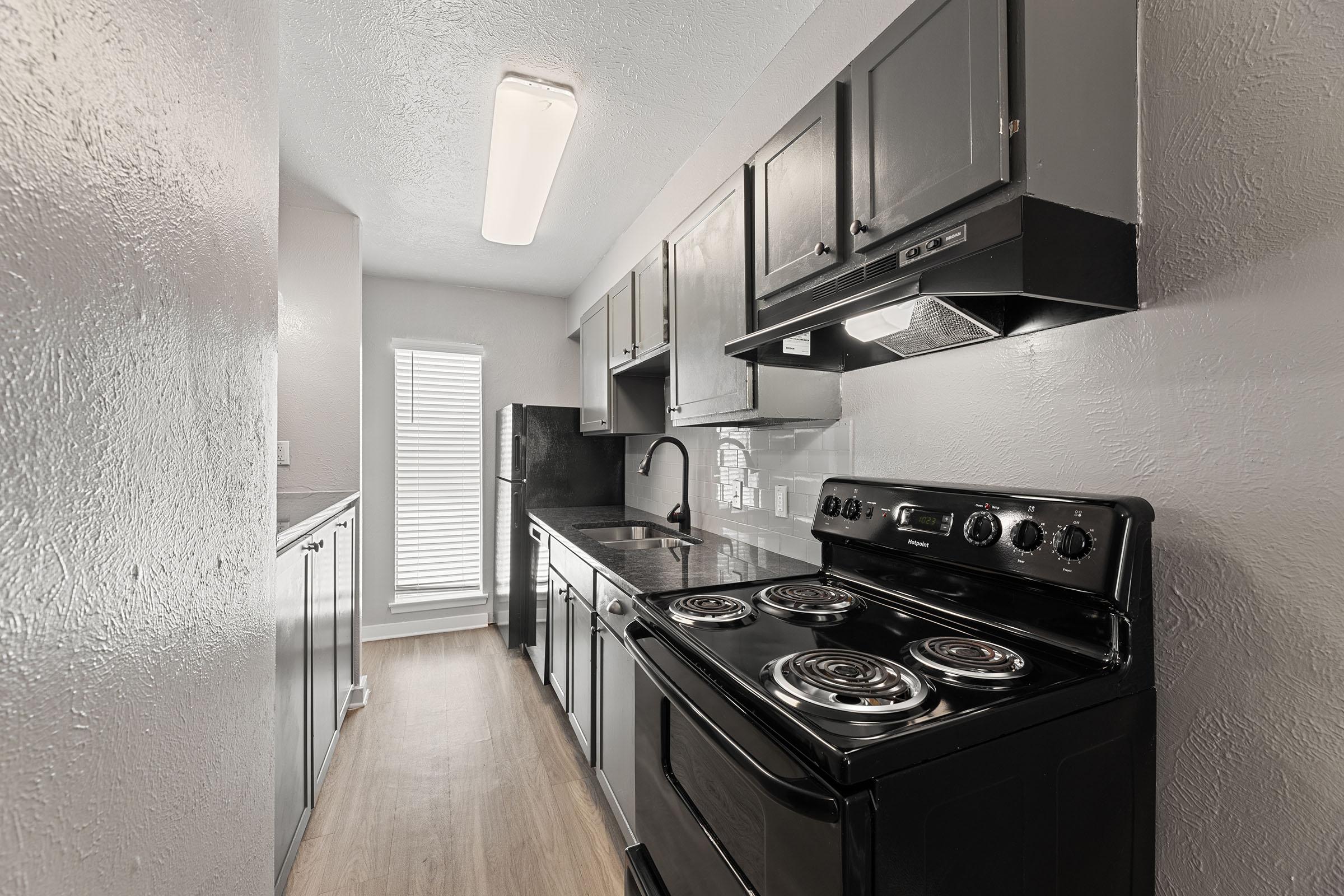 a stove top oven sitting inside of a kitchen