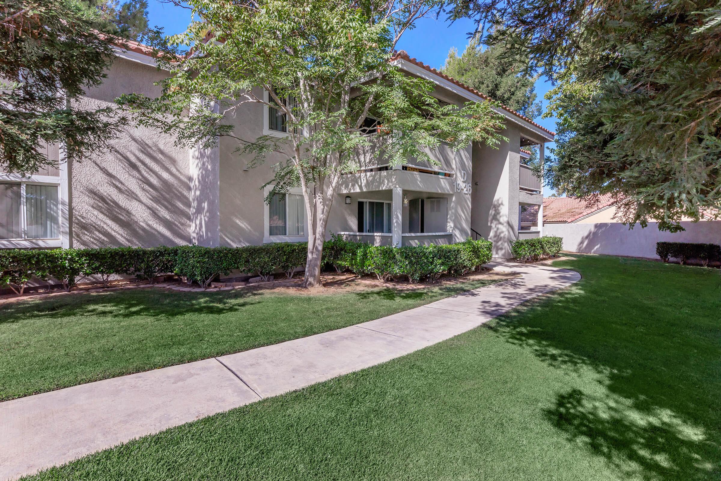 a path with grass in front of a house