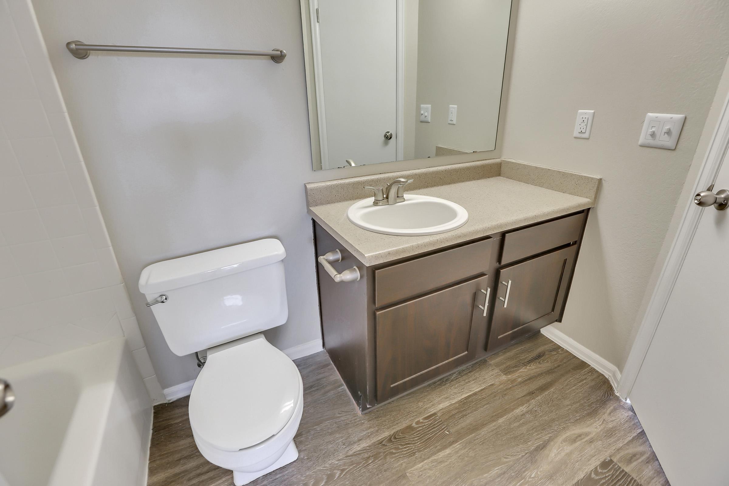 a white sink sitting under a mirror