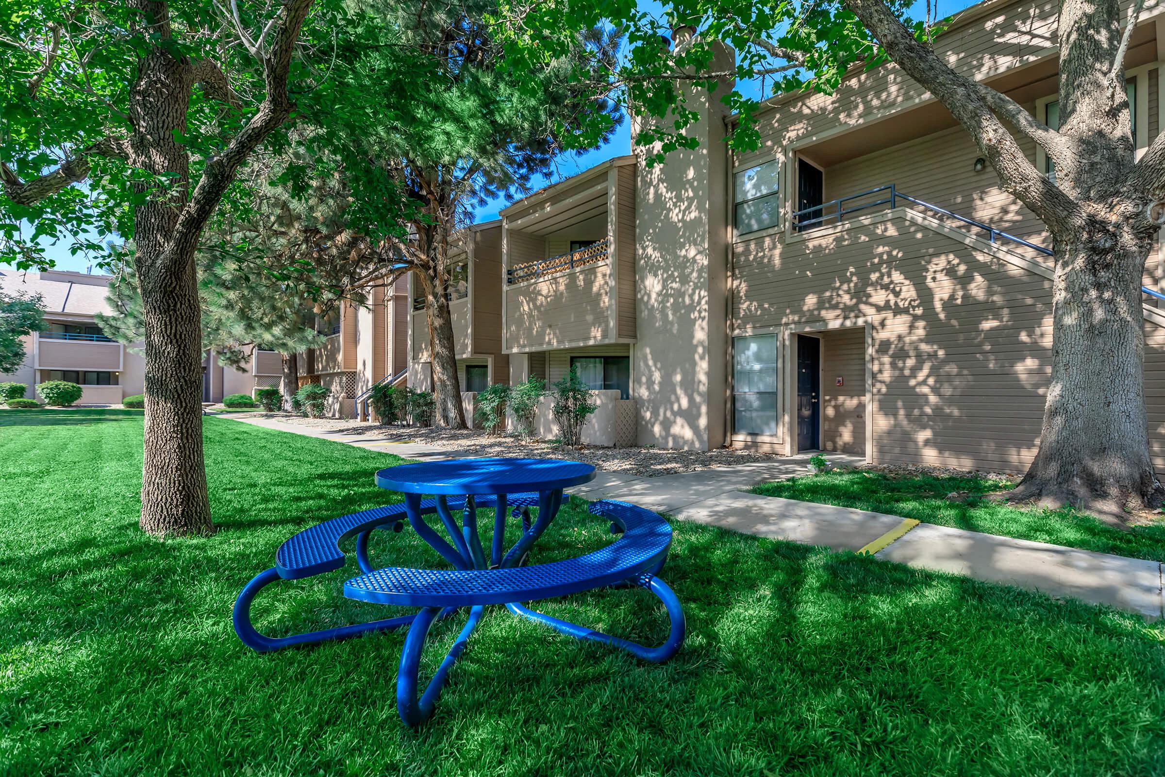 blue picnic table in front of community building