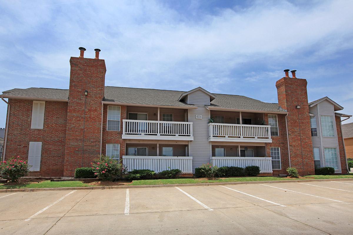 a large brick building with a clock on the side of a road