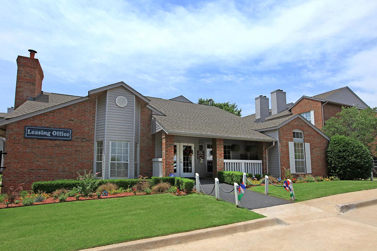 a large brick building with grass in front of a house