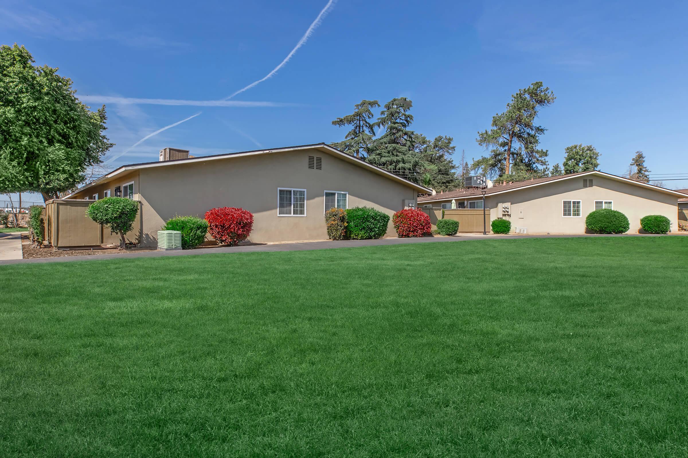 a large green field in front of a house