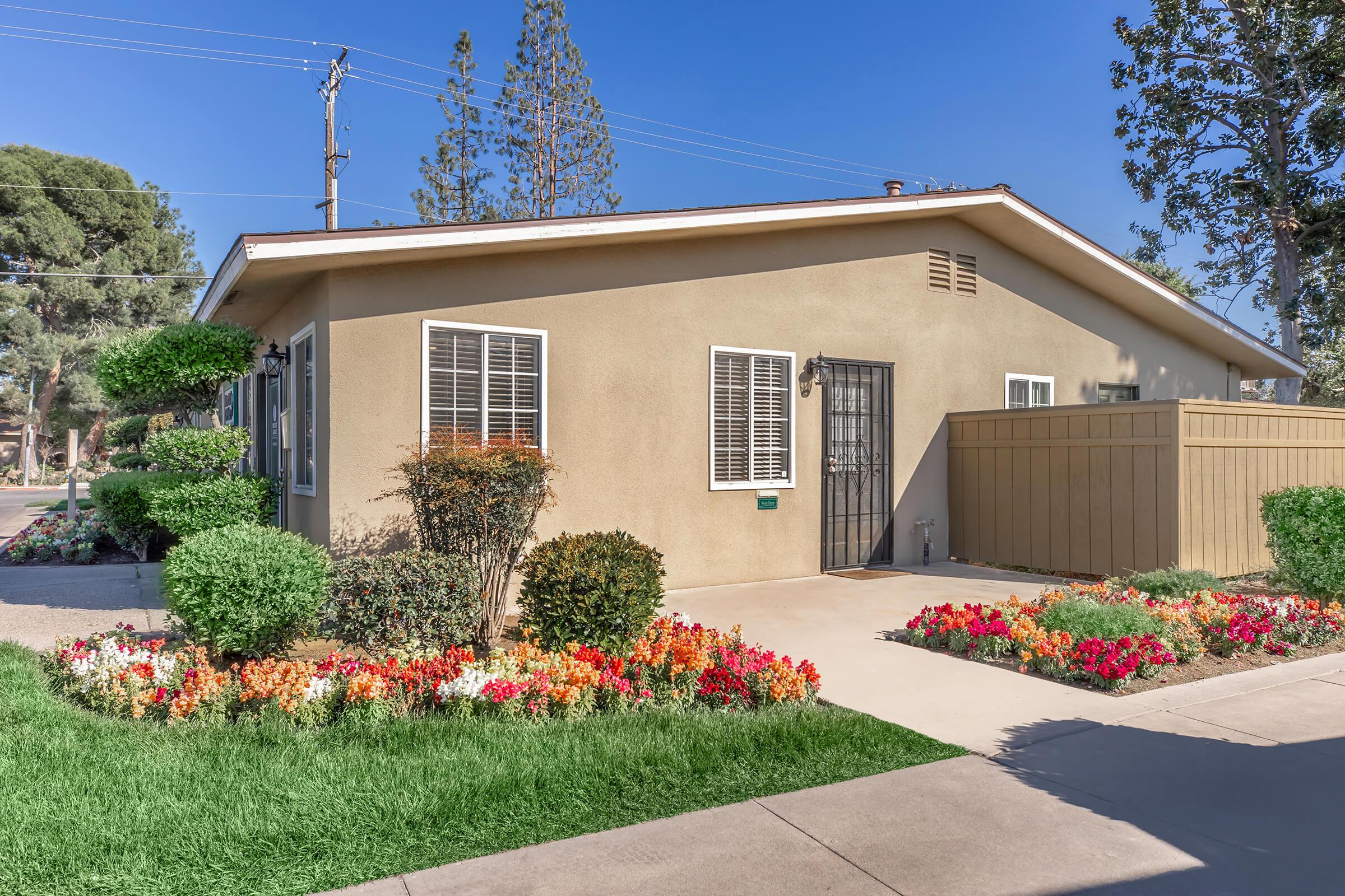 a close up of a flower garden in front of a house