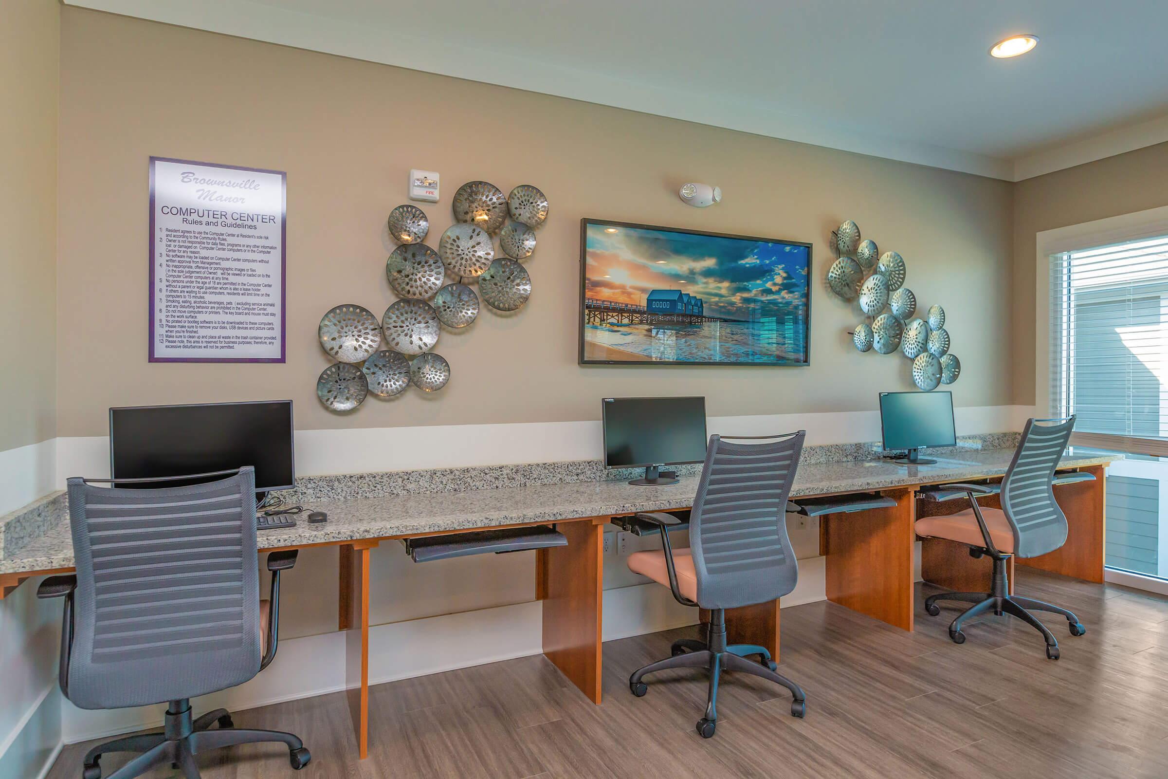 a desk with a computer and a chair in a room