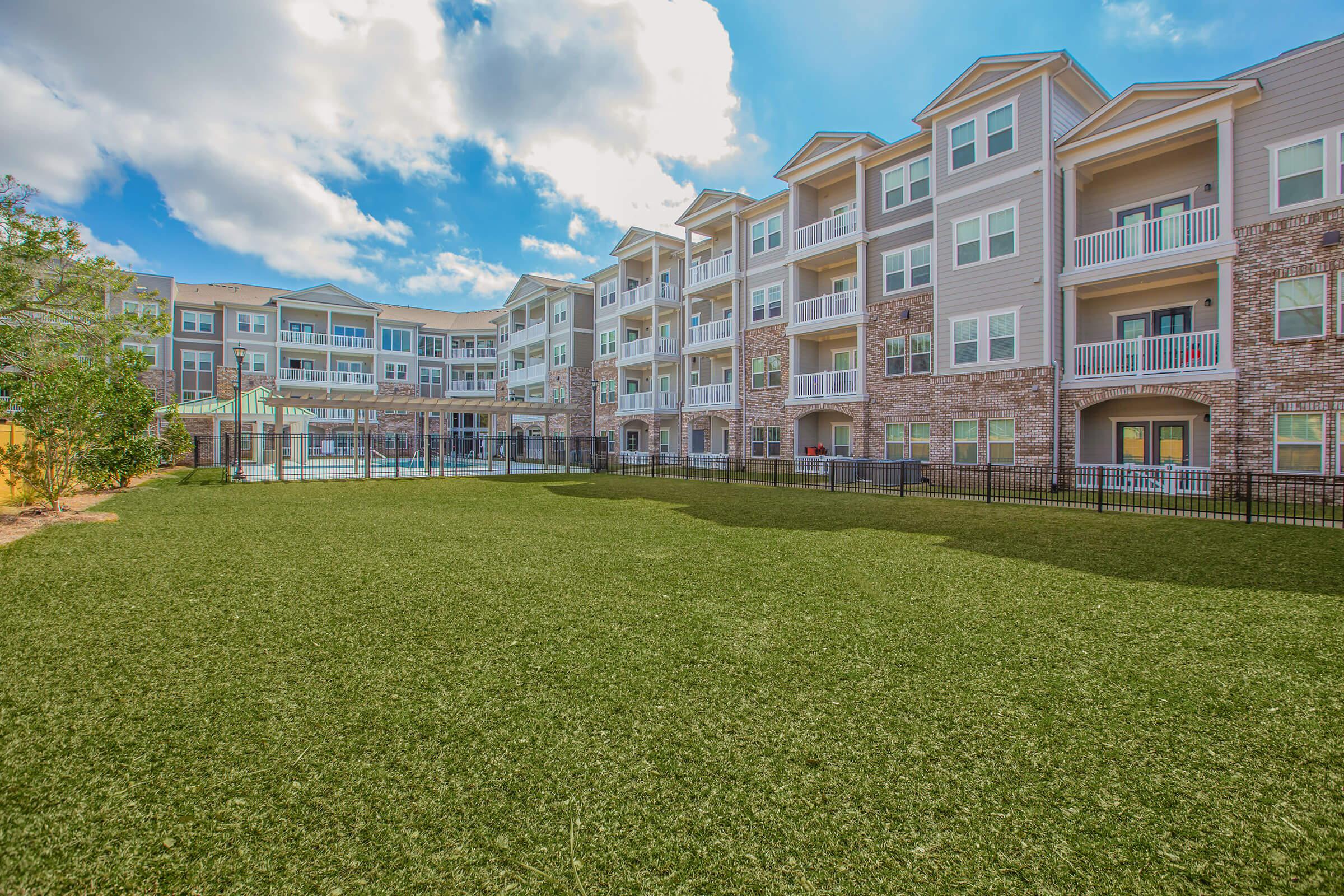 a large green field in front of a building