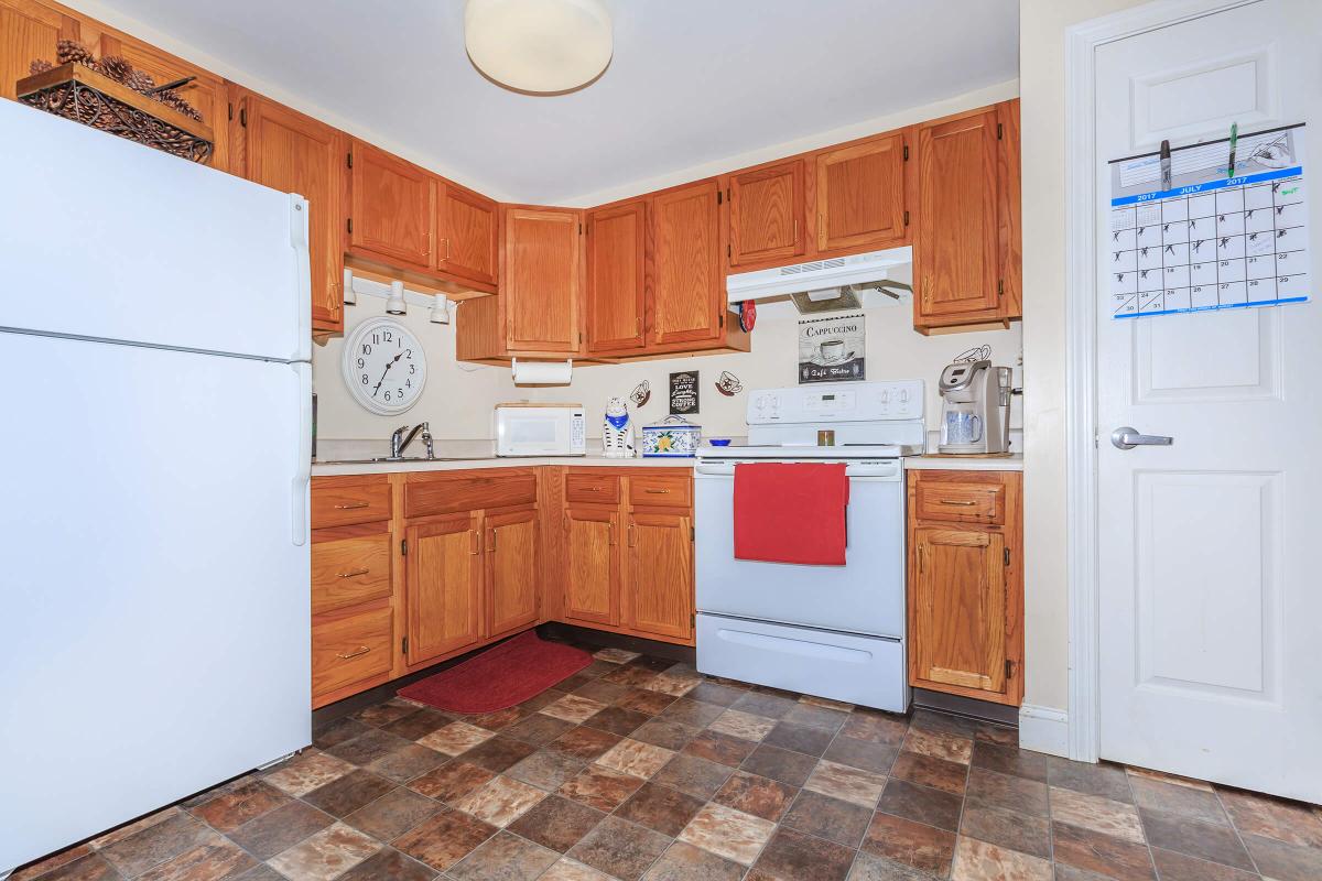 a kitchen with wooden cabinets and a refrigerator