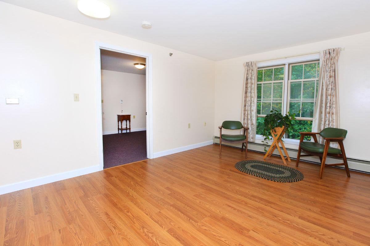 a living room filled with furniture on top of a hard wood floor