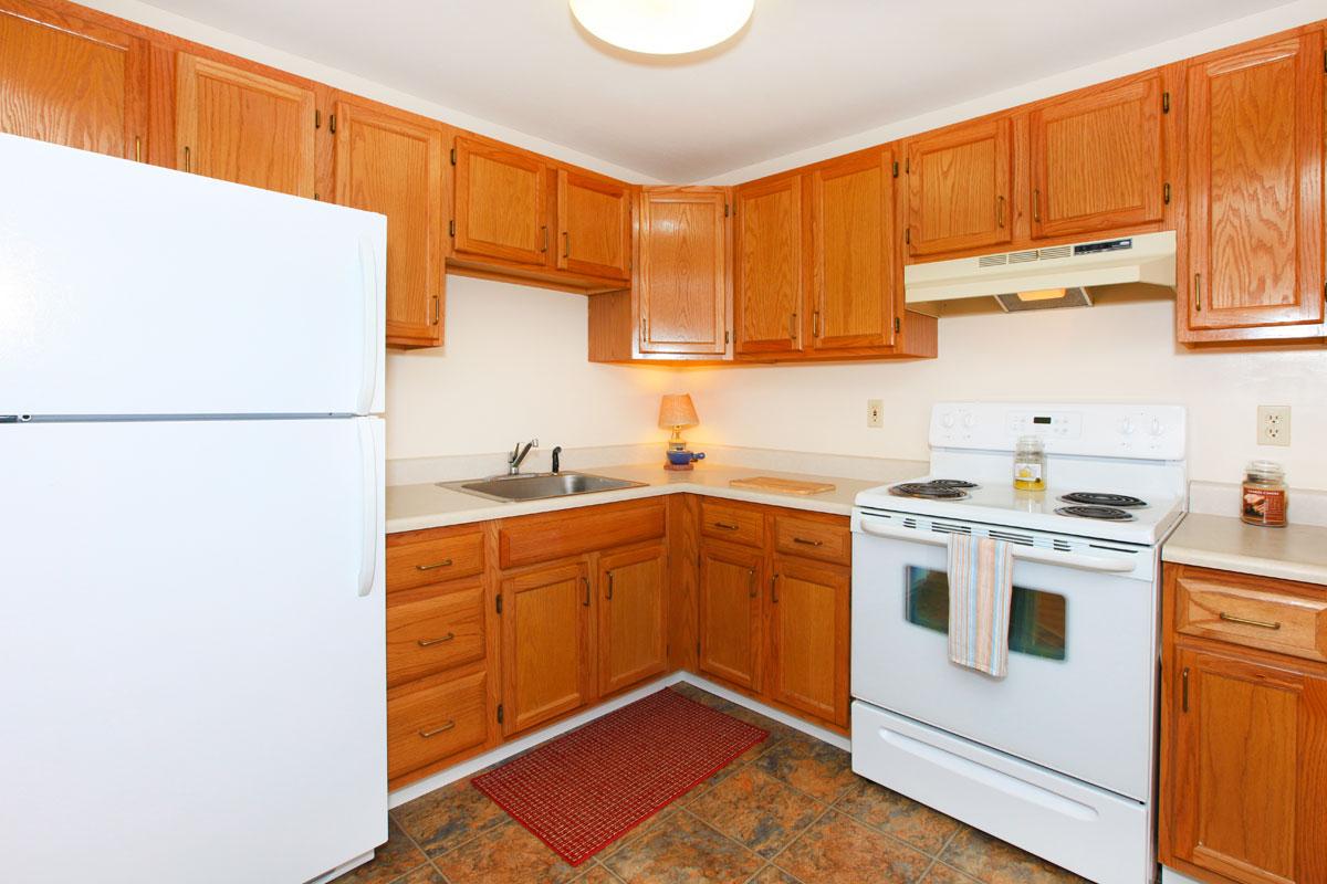 a kitchen with white appliances and wooden cabinets