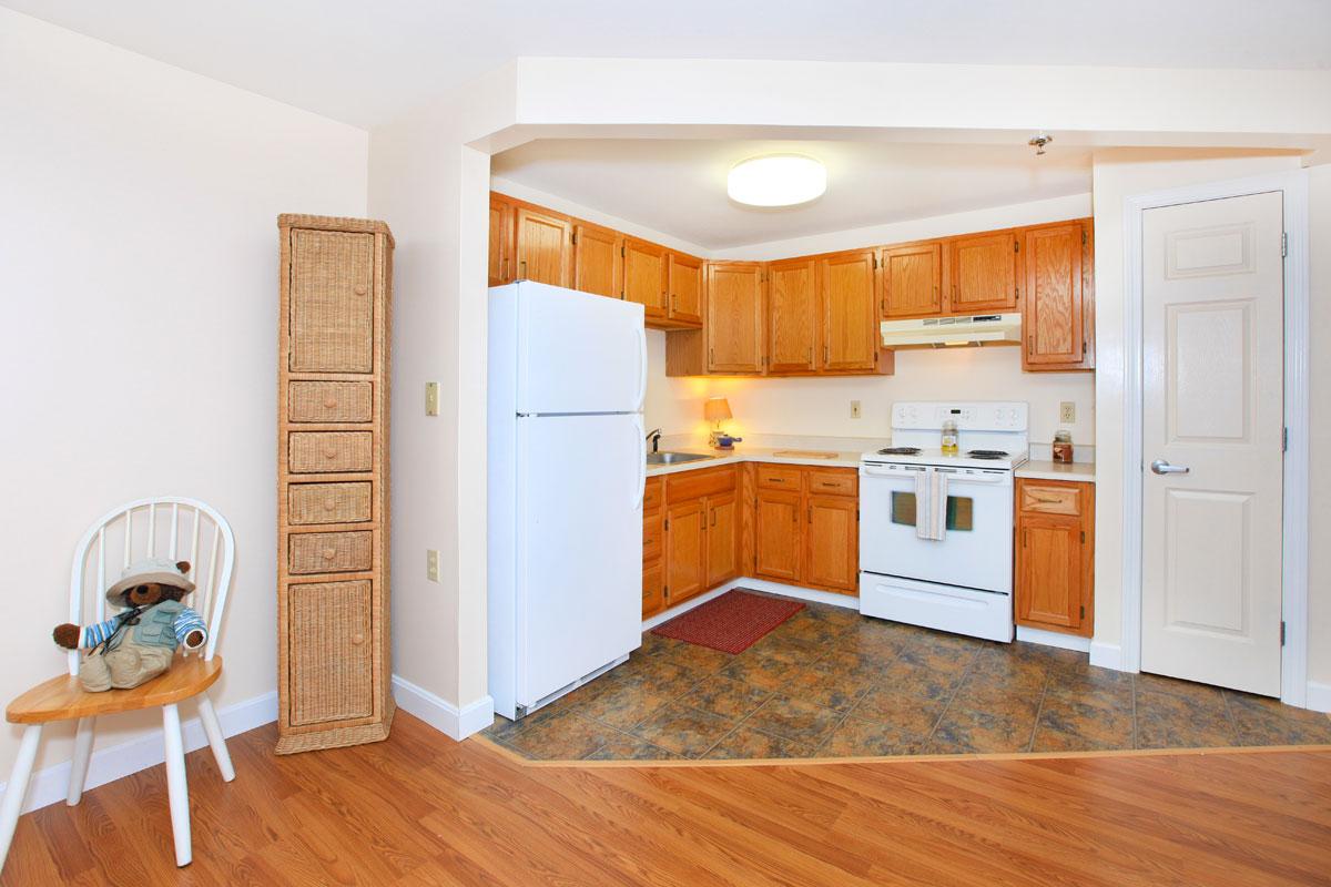 a kitchen with wooden cabinets and a wood floor