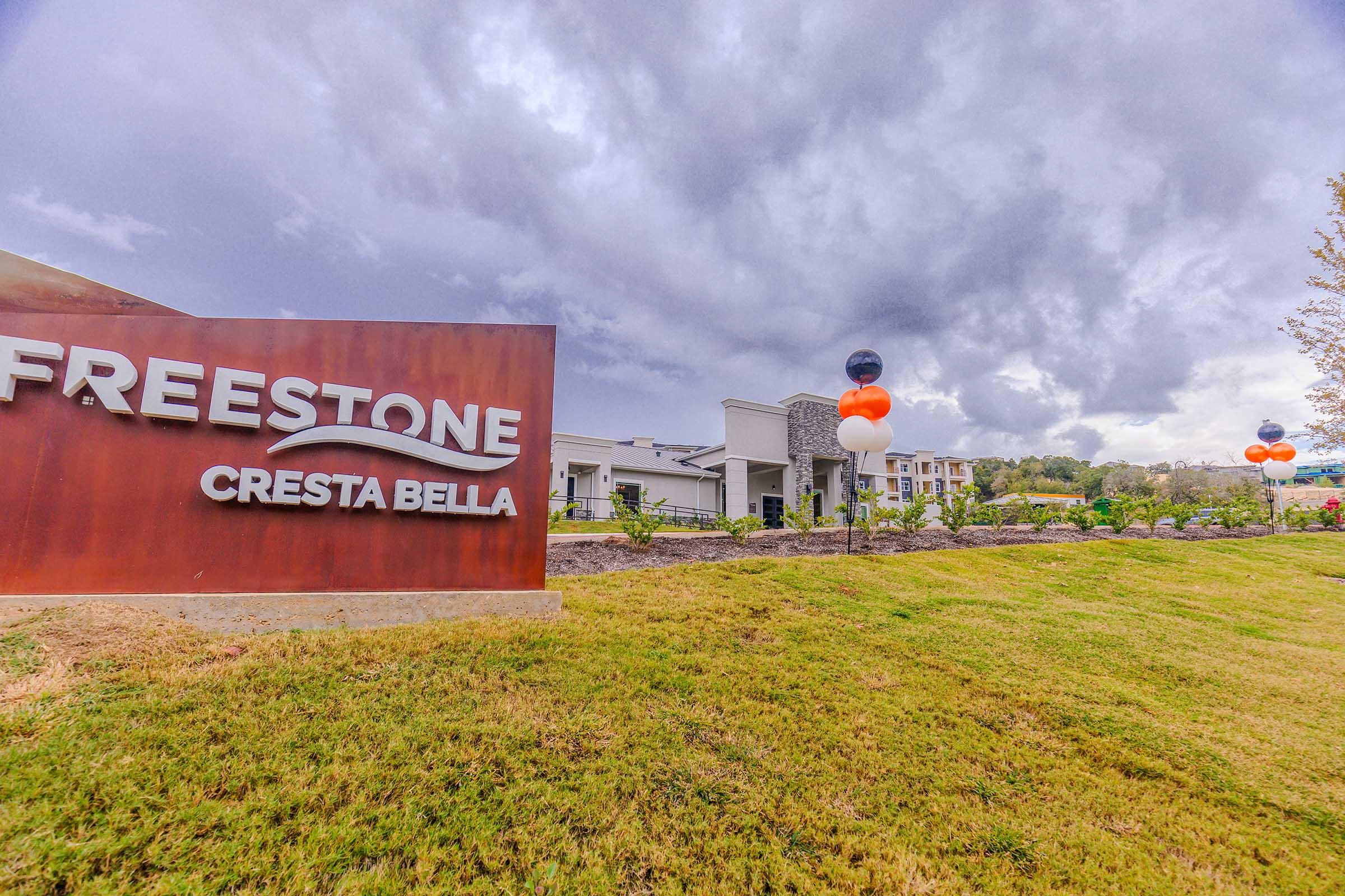 a sign above a grassy field