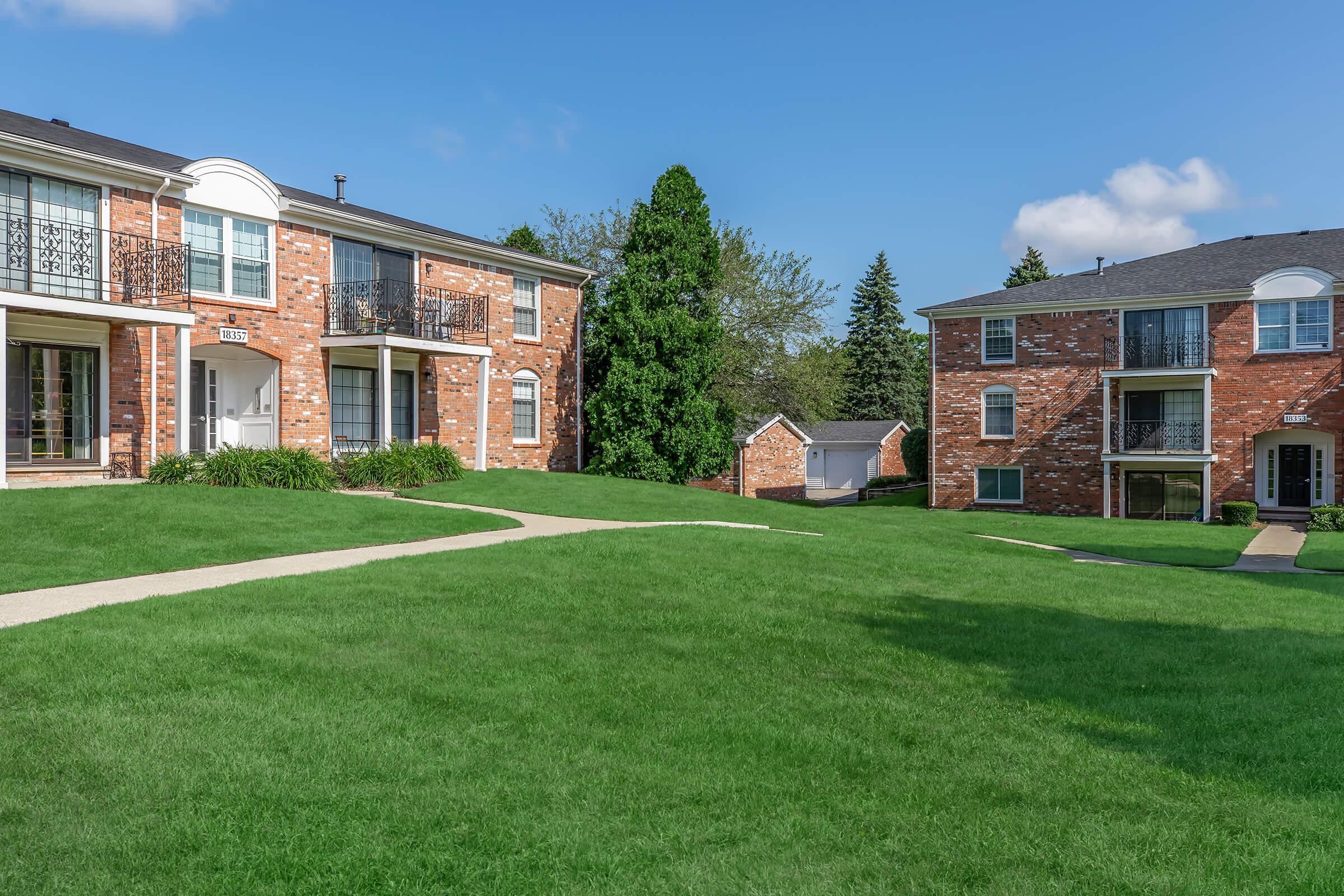 a large lawn in front of a brick building