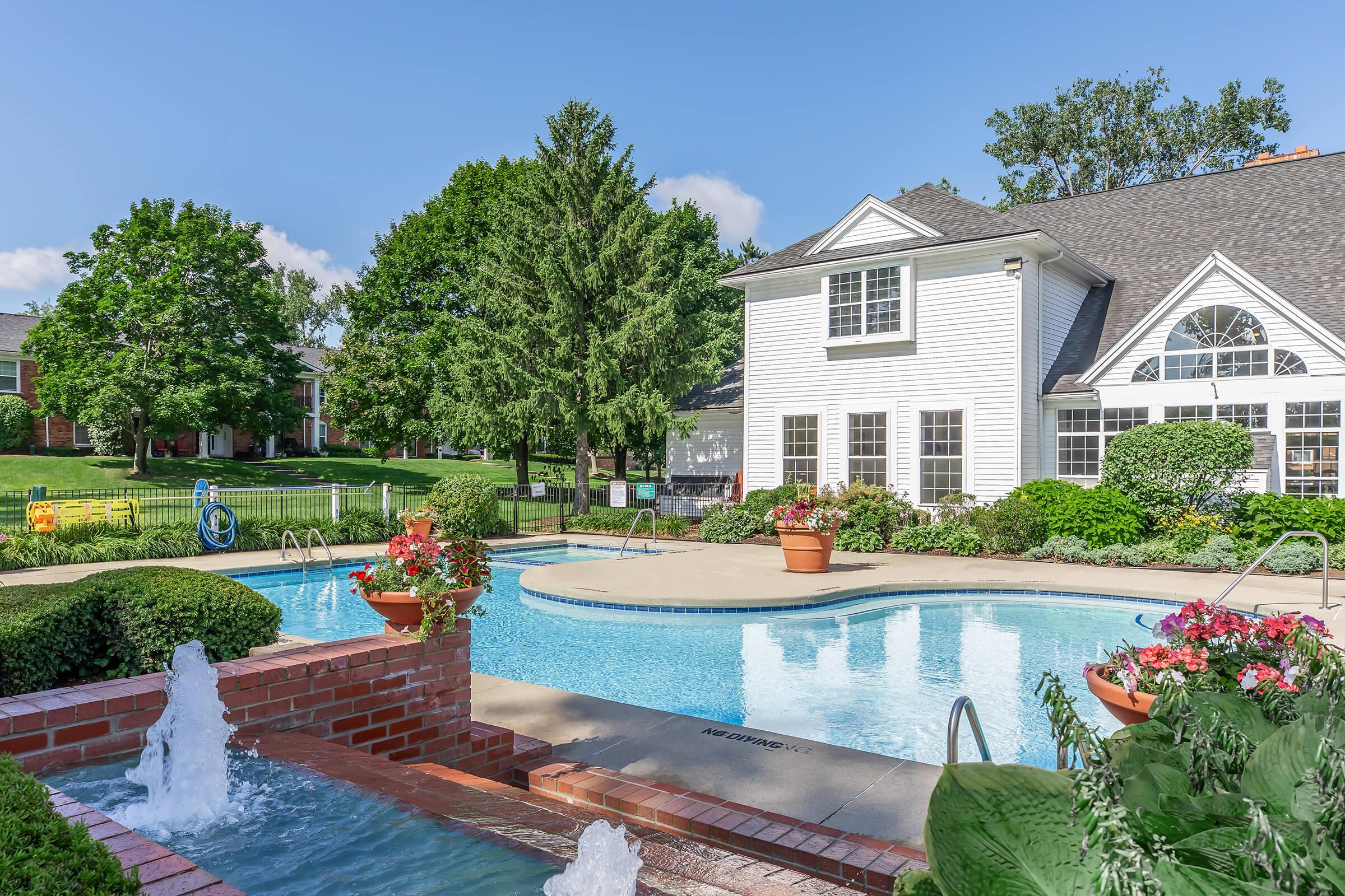 a garden with water in front of a house