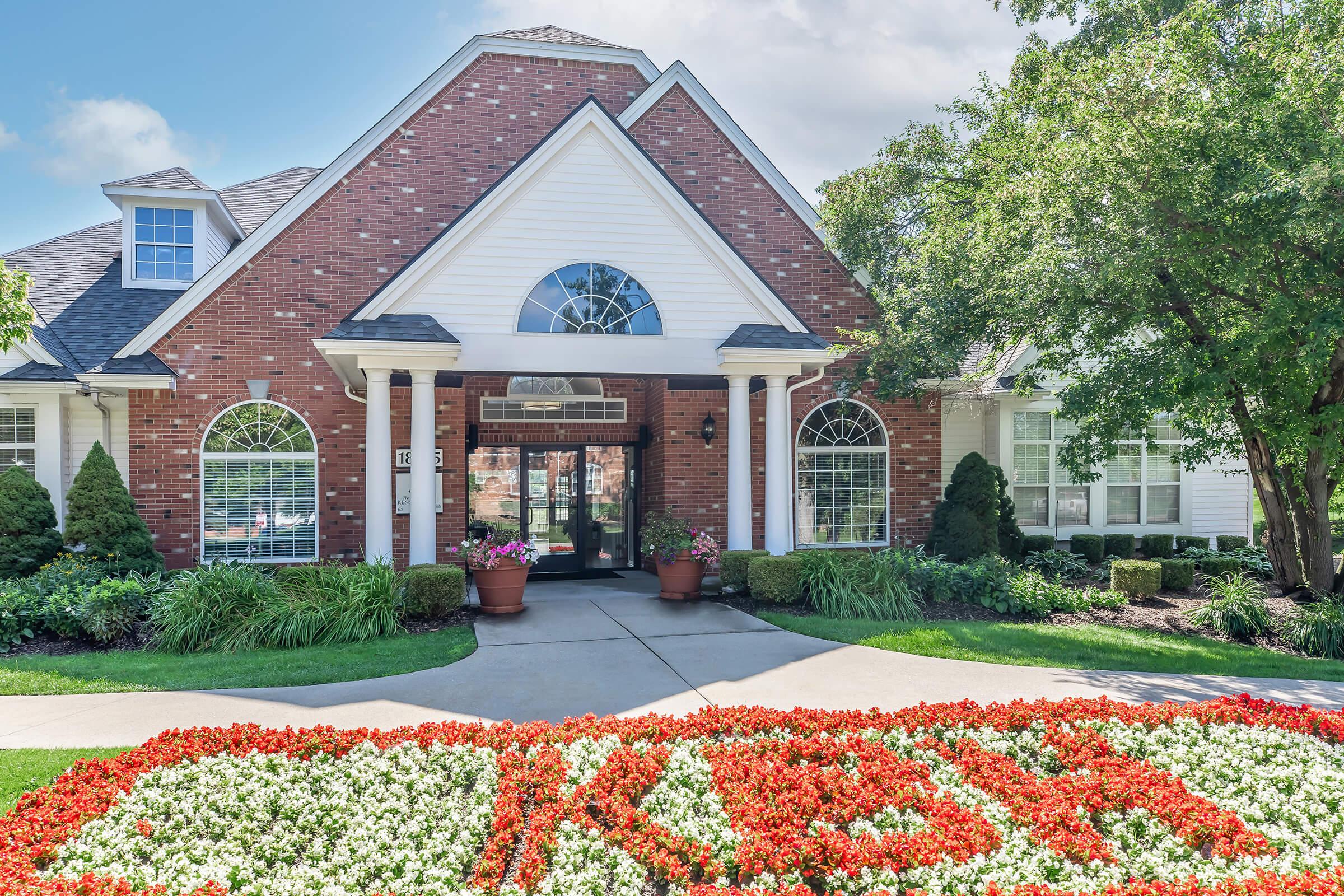 a large brick building with grass in front of a house