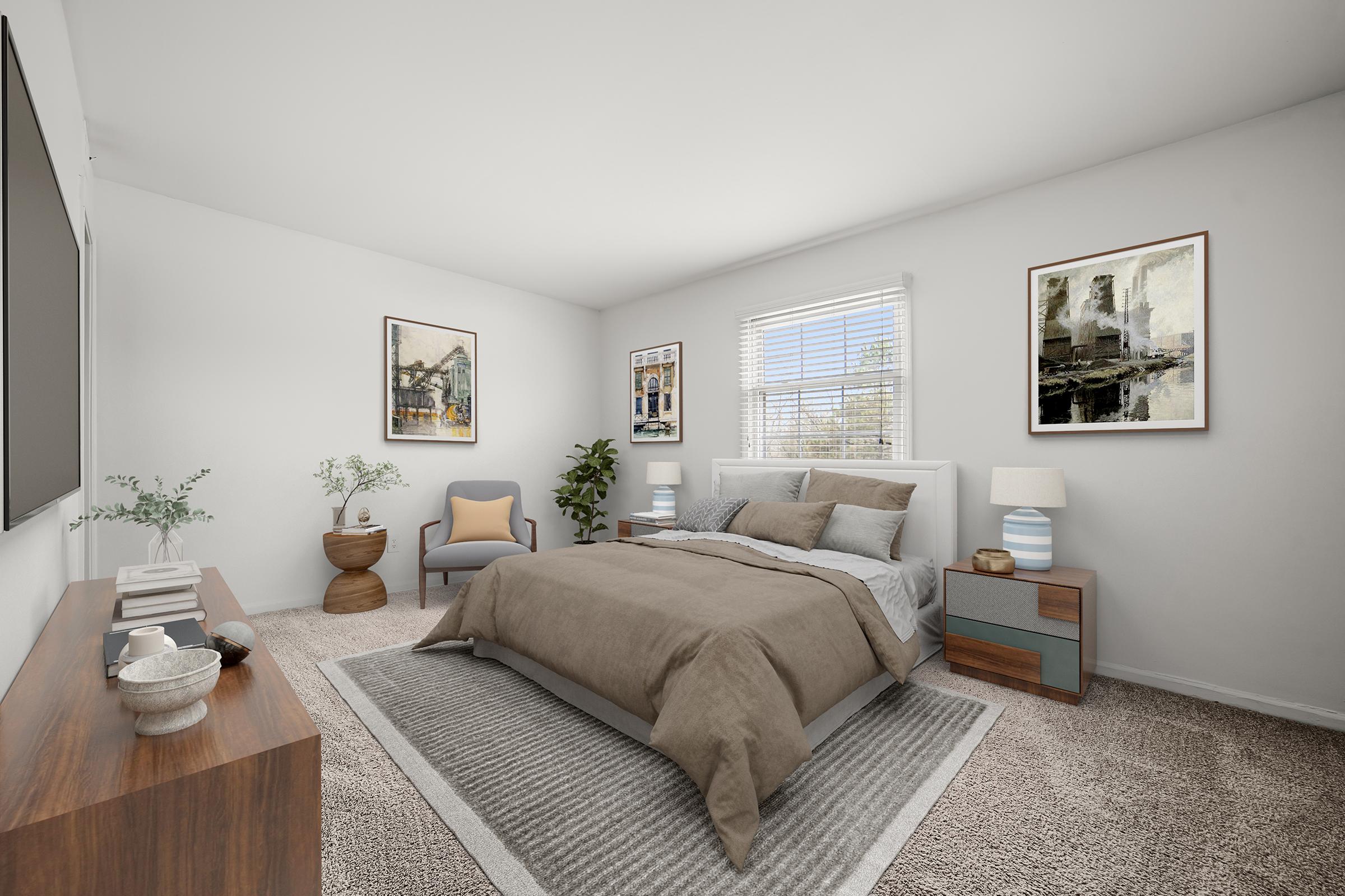 A modern bedroom featuring a bed with a brown and beige comforter, a cozy armchair, and a wooden dresser. The room has light-colored walls, large windows, framed artworks, and decorative plants, creating a calm and inviting atmosphere. Soft carpeting covers the floor.